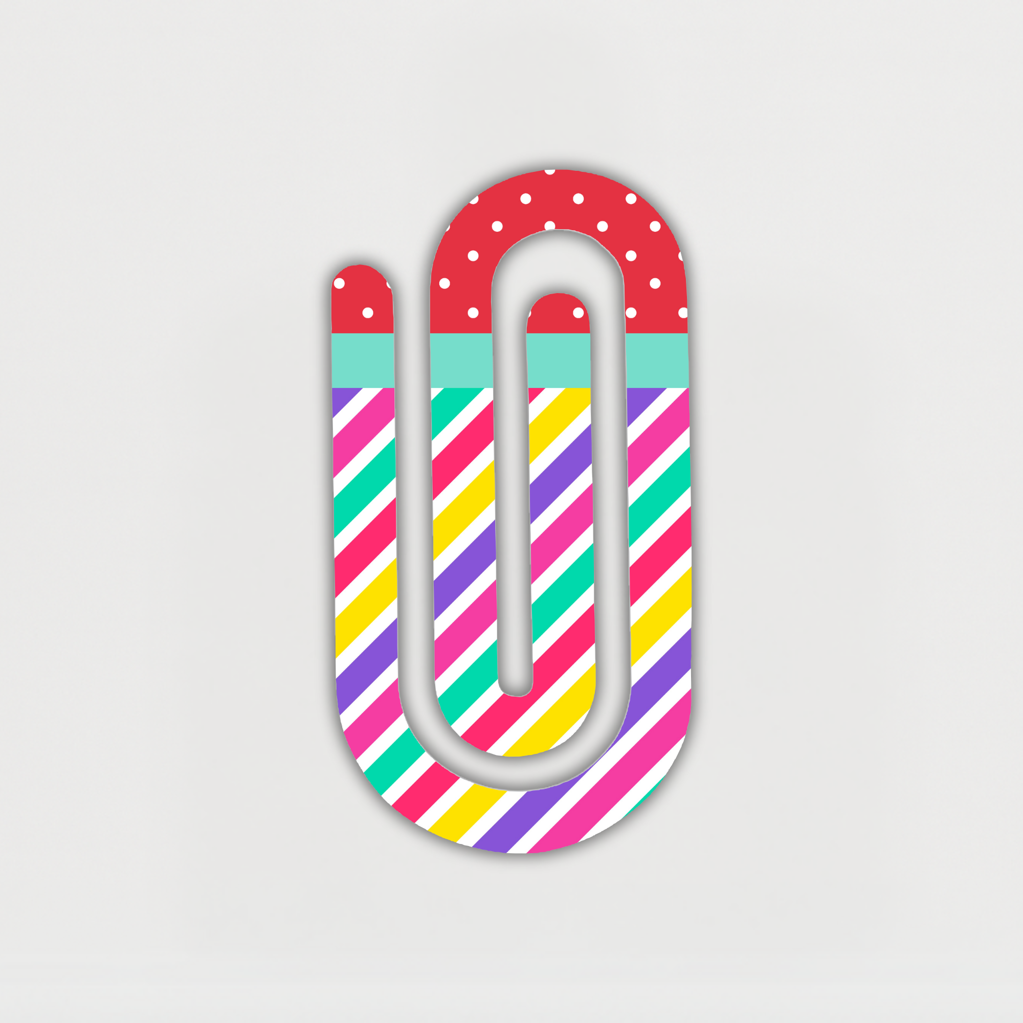 Colorful jumbo acrylic paperclip with stripes and polka dots on white background.
