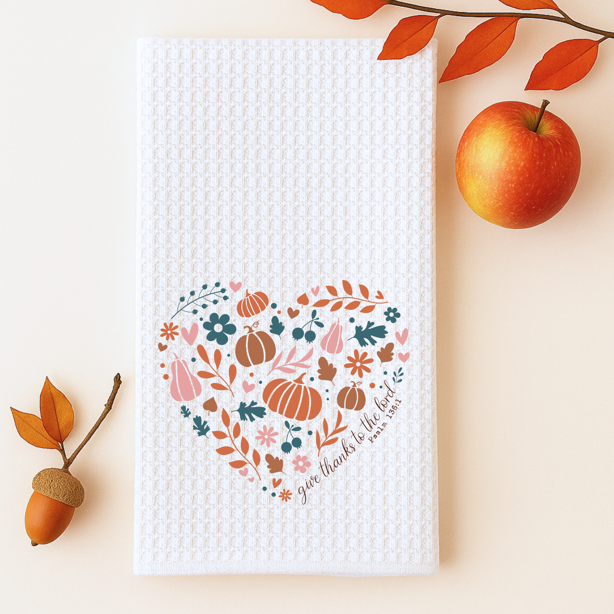 Faith-inspired fall dish towel with pumpkins and florals placed beside apple and acorn decor.