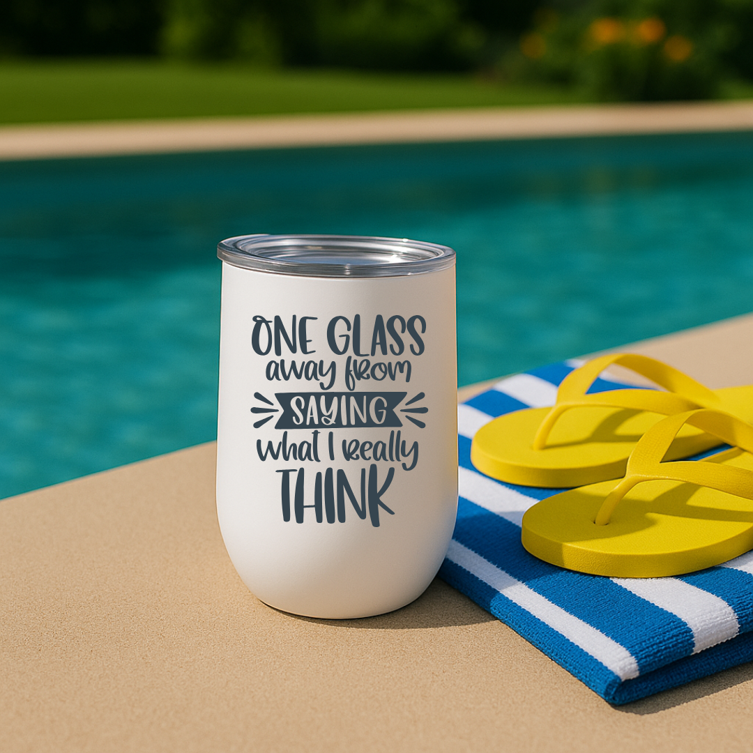 White wine tumbler by a pool with charcoal “One Glass Away From Saying What I Really Think” print.