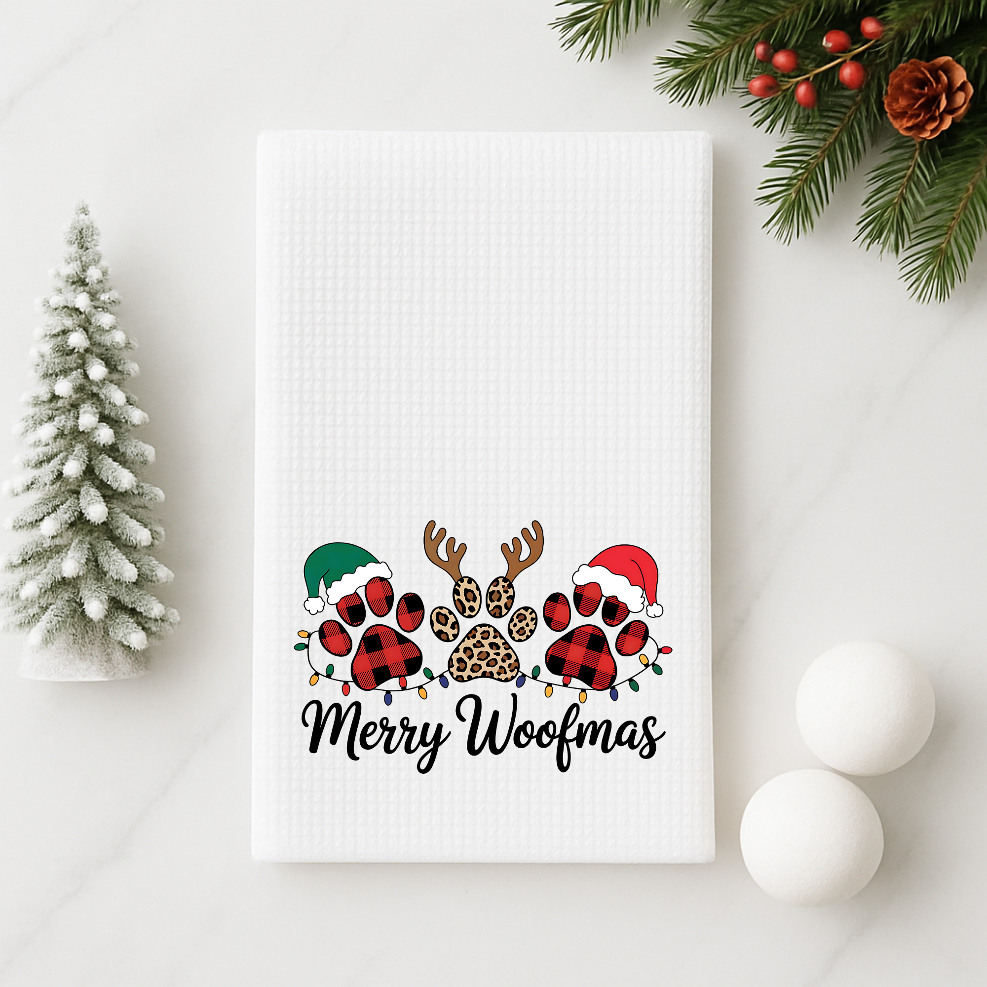 Merry Woofmas dog Christmas kitchen towel styled with minimalist holiday decor and greenery.