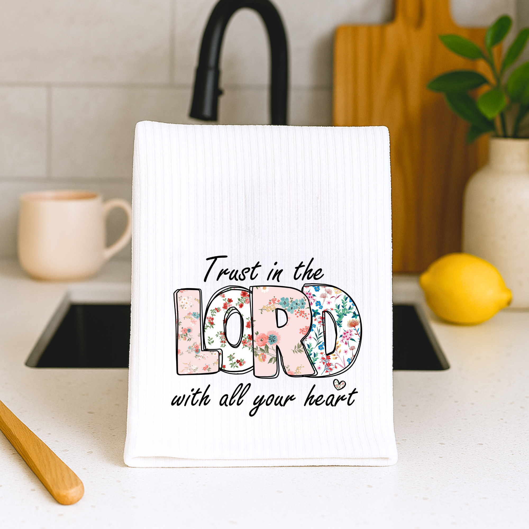 Faith inspired dish towel with floral Lord design displayed by farmhouse sink.