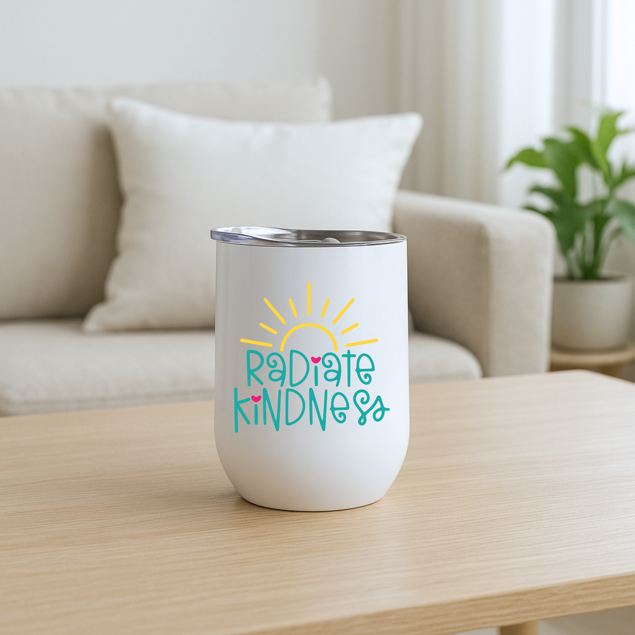 Radiate Kindness stainless steel wine tumbler on a wood coffee table in a cozy living room