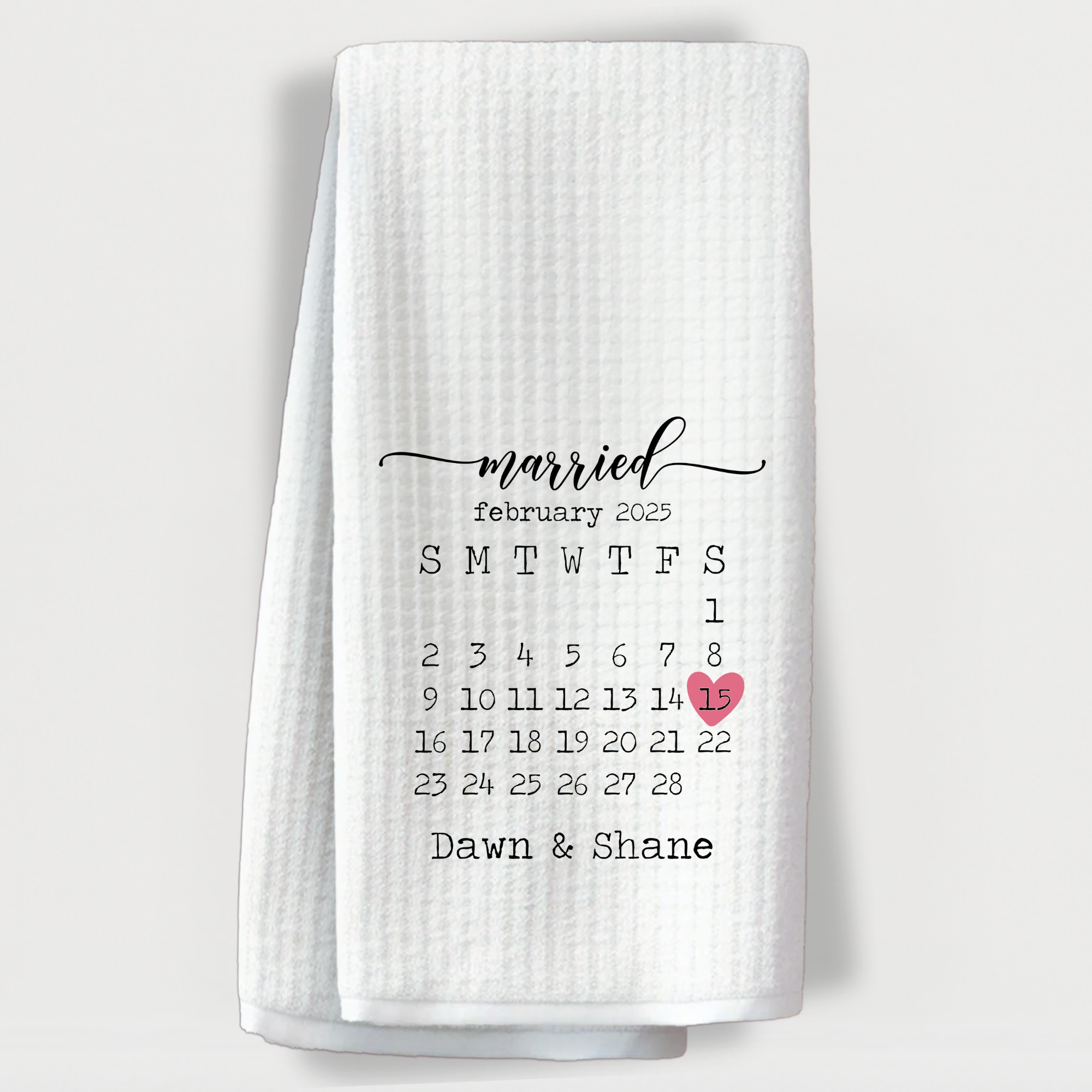 "Custom wedding towel with February 2025 calendar and pink heart marking anniversary date with couple’s names."