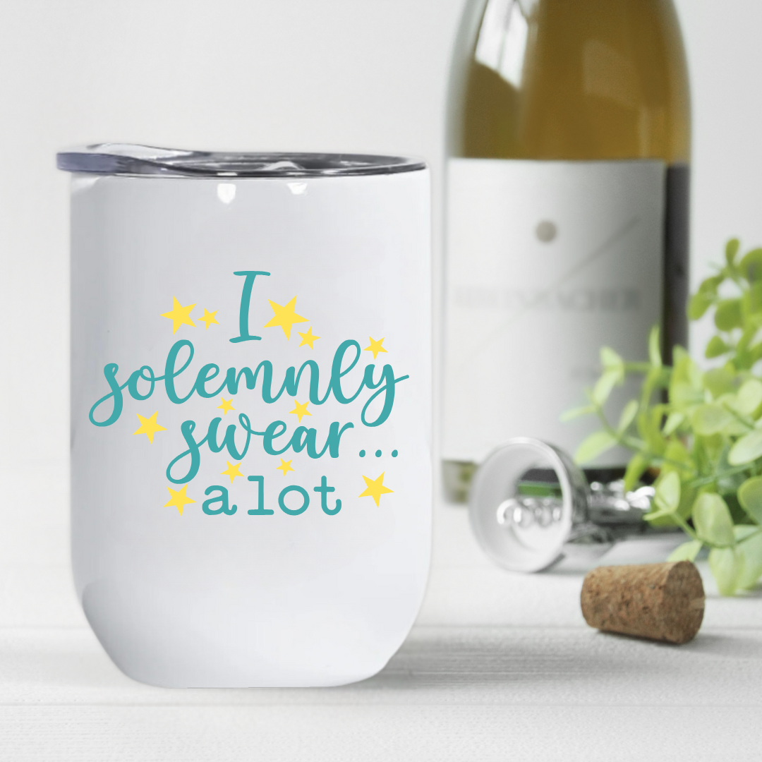 Teal and yellow “I Solemnly Swear a Lot” tumbler next to a wine bottle, a humorous and stylish gift for wine lovers and party hosts.