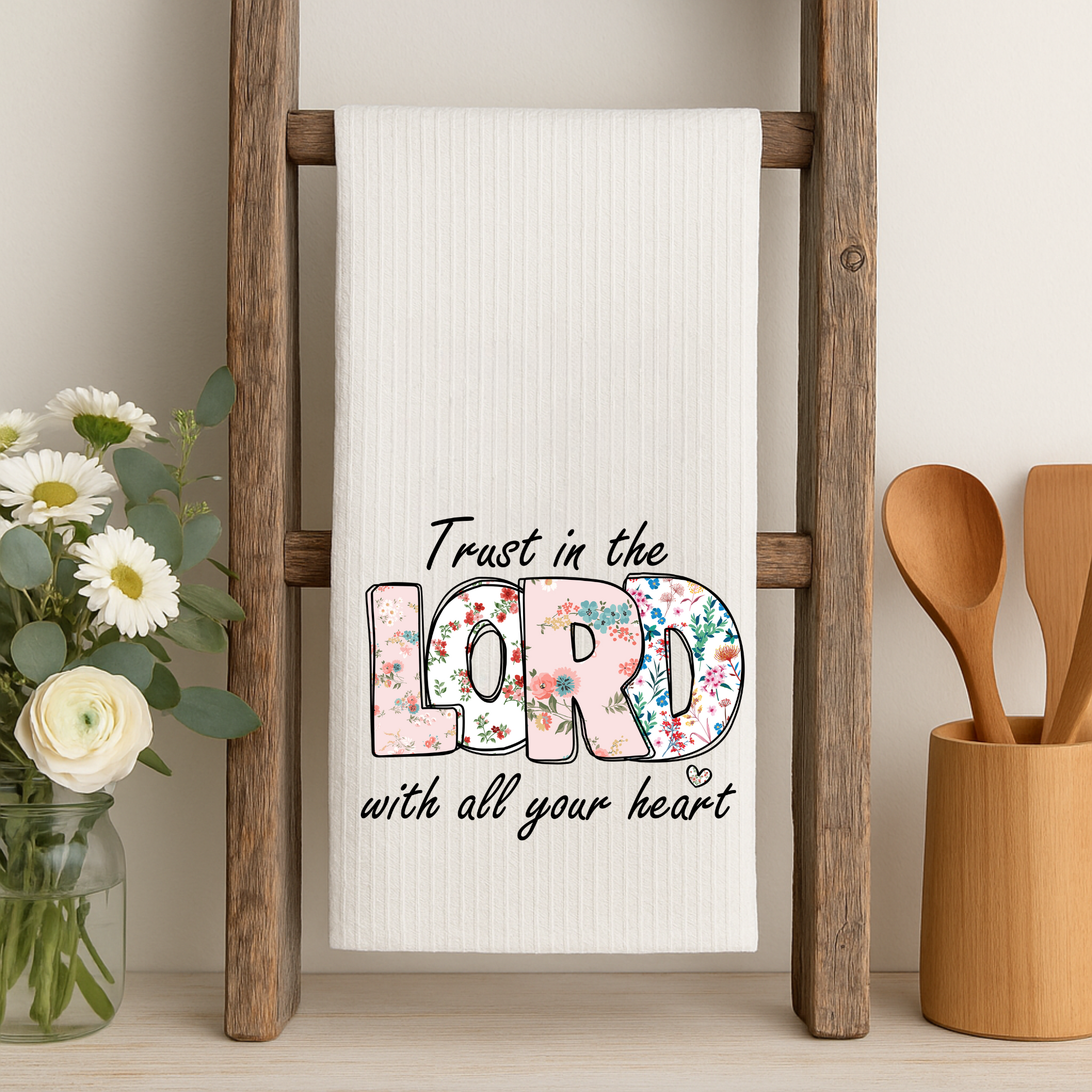 Floral Christian dish towel with Bible verse displayed on rustic wood ladder.