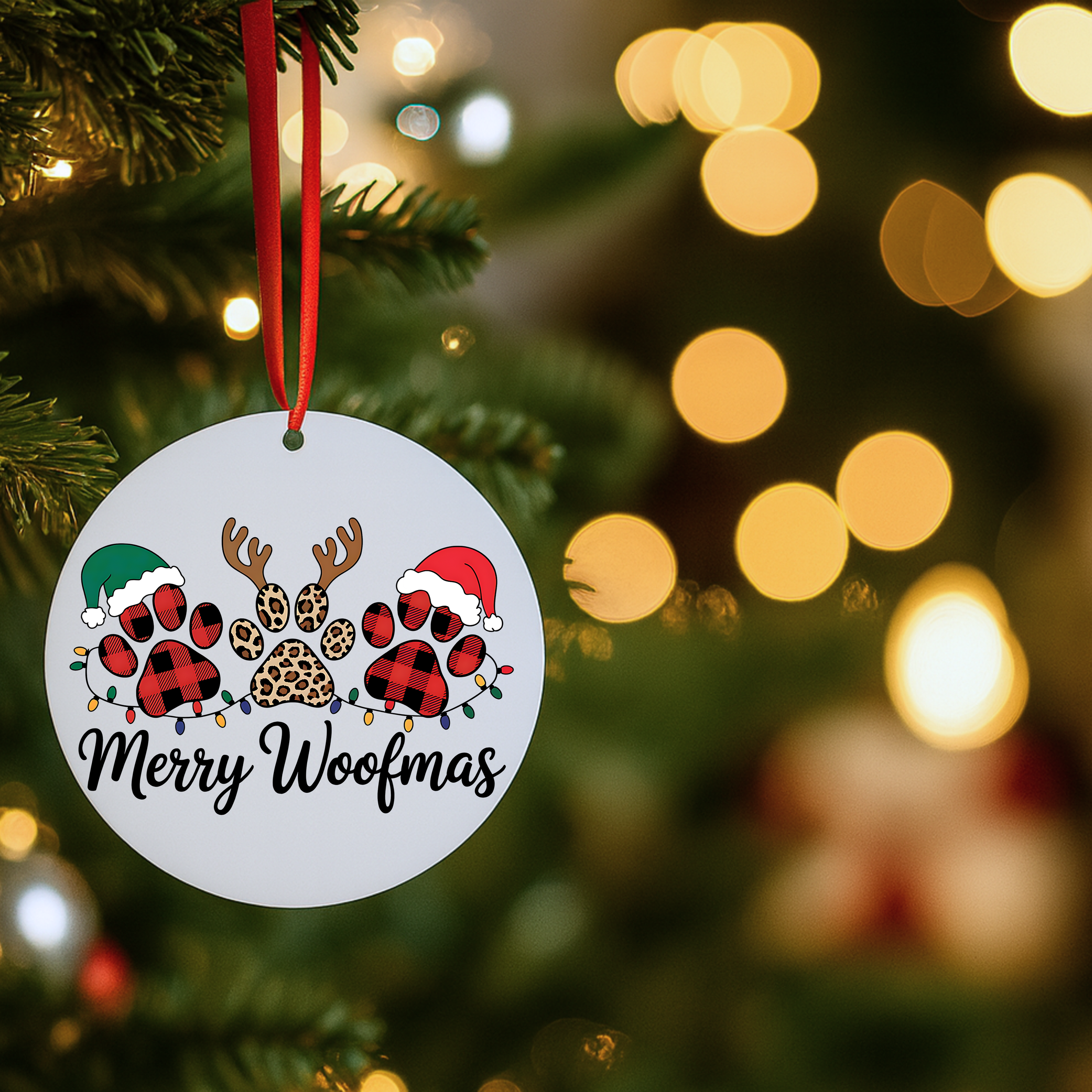 Merry Woofmas dog Christmas ornament hanging on a Christmas tree with soft golden holiday lights.