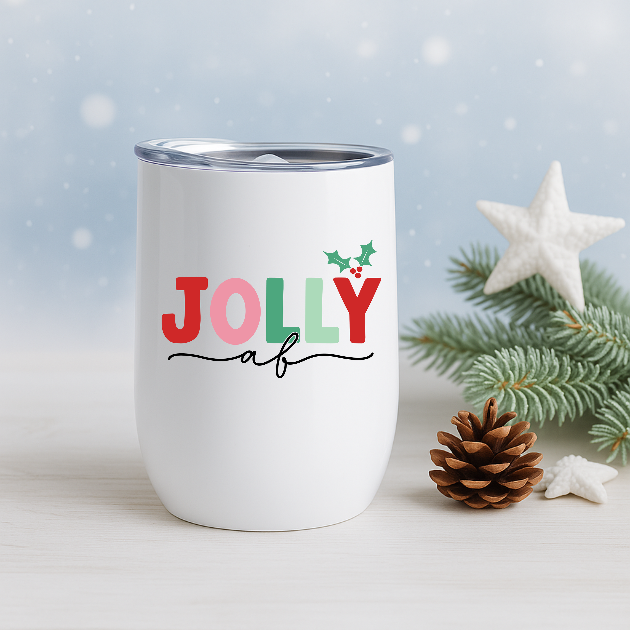 Jolly AF tumbler with pine branches, pinecones, and a white Christmas star decoration.