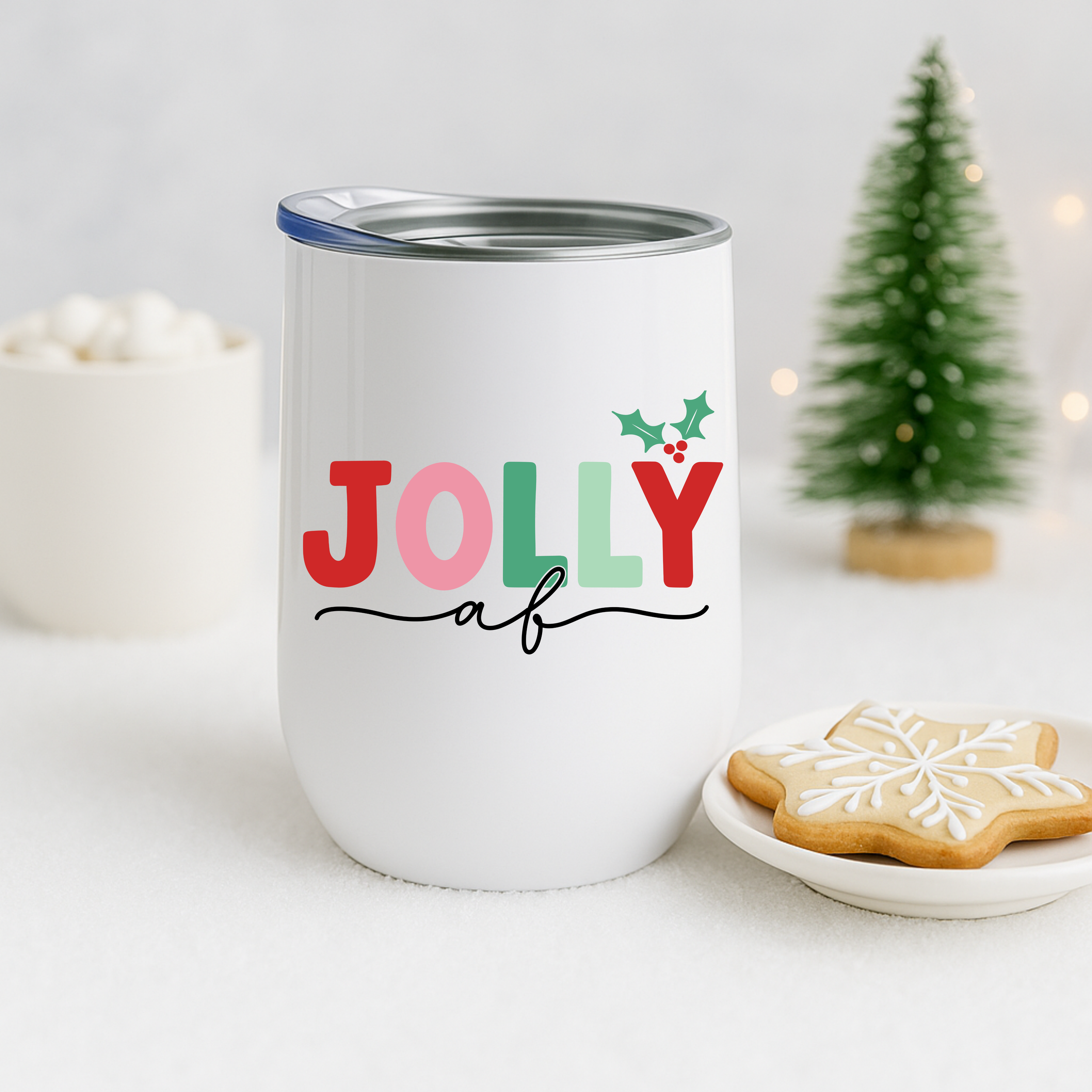 Jolly AF tumbler styled with a snowflake cookie, mini tree, and festive holiday decor.