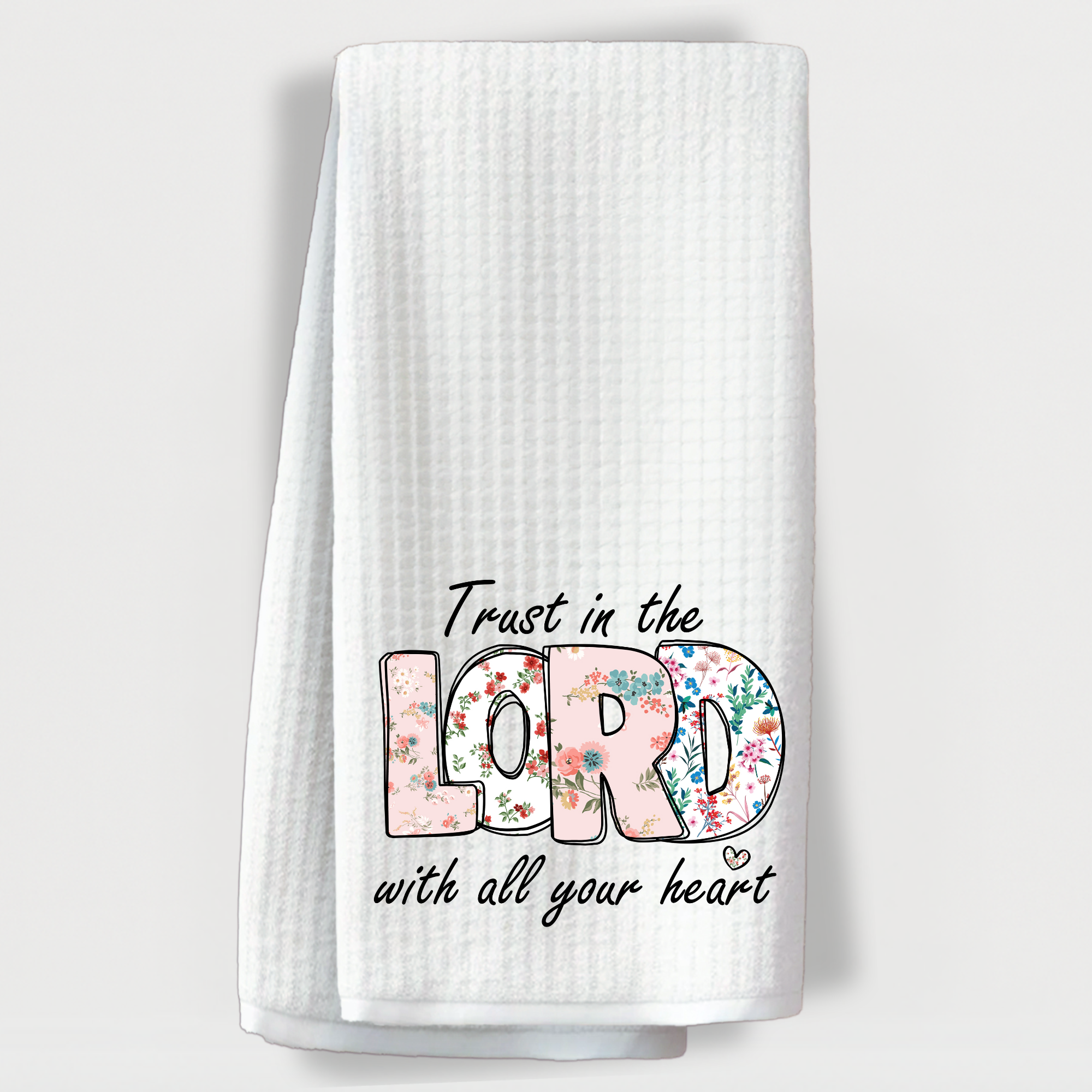 Faith based floral kitchen towel with Trust in the Lord verse on white background.