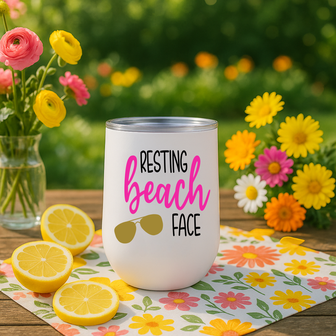White wine tumbler on picnic table with “Resting Beach Face” design in magenta pink and sunglasses graphic.