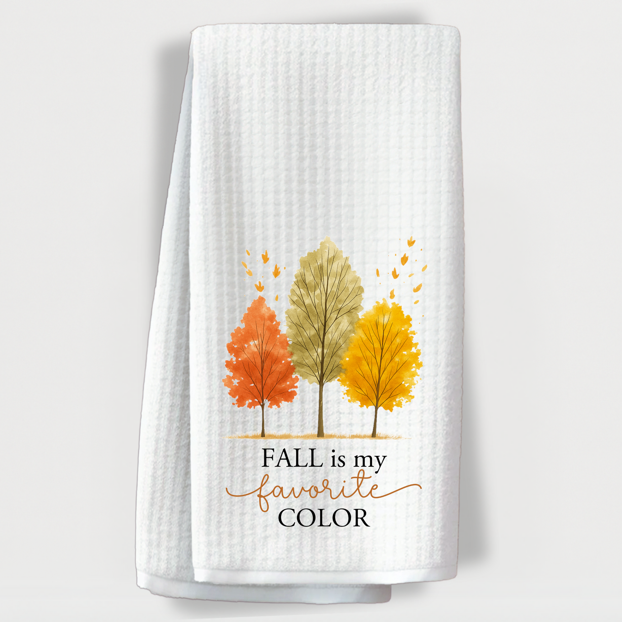 White waffle weave fall towel with watercolor tree design and “Fall is My Favorite Color” text displayed studio-style.