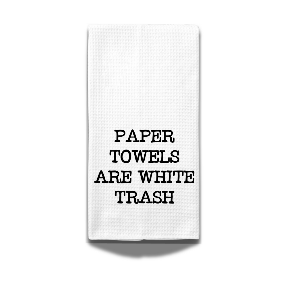 Close-up of a white microfiber towel with bold black text “Paper Towels Are White Trash” on a white background.