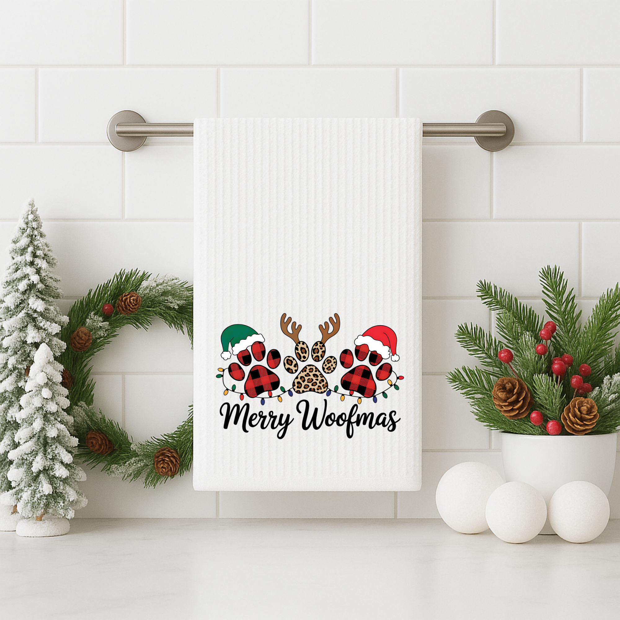 Merry Woofmas dog Christmas towel displayed on a bathroom towel bar with holiday greenery.