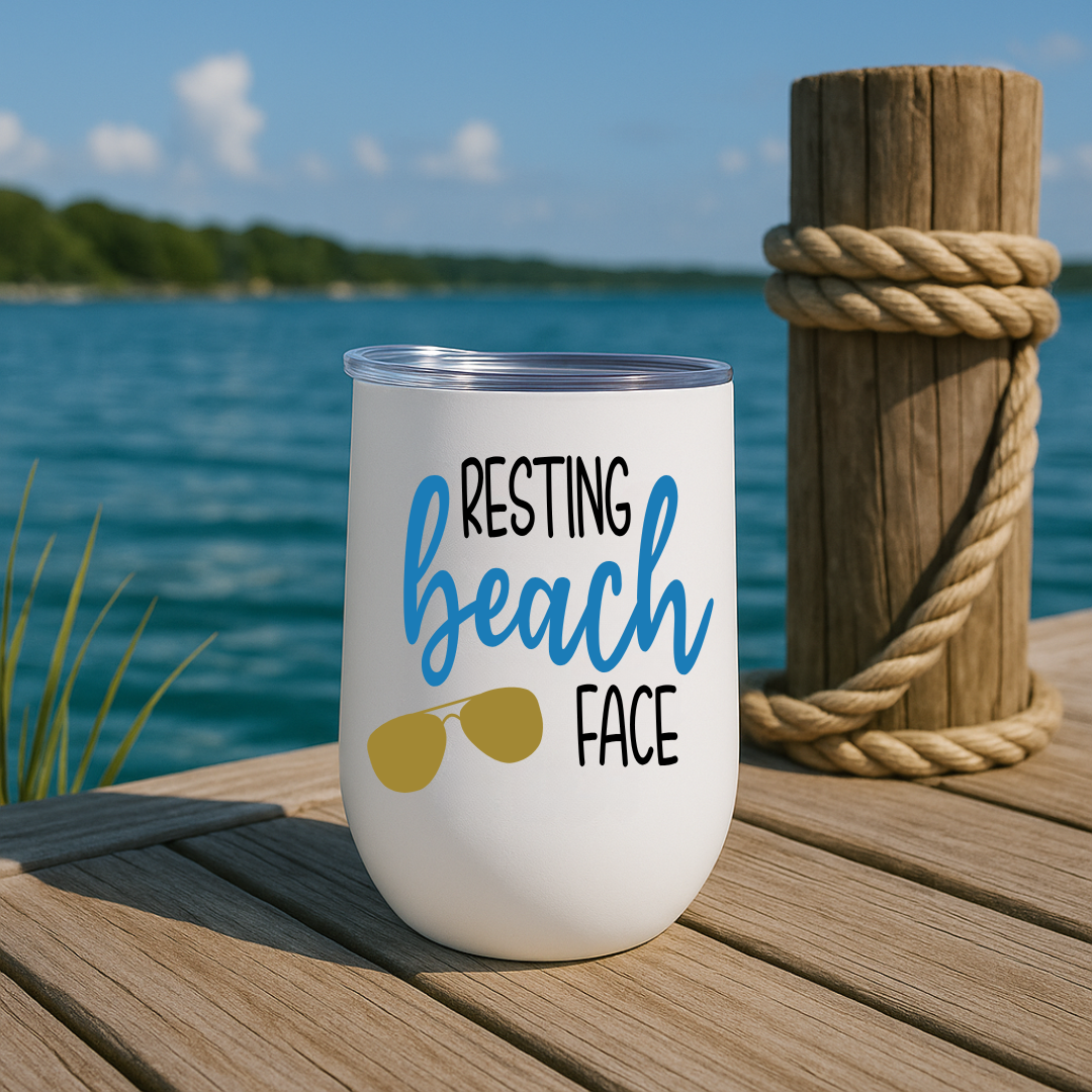 White wine tumbler on dock with “Resting Beach Face” design in eastern blue and sunglasses graphic.