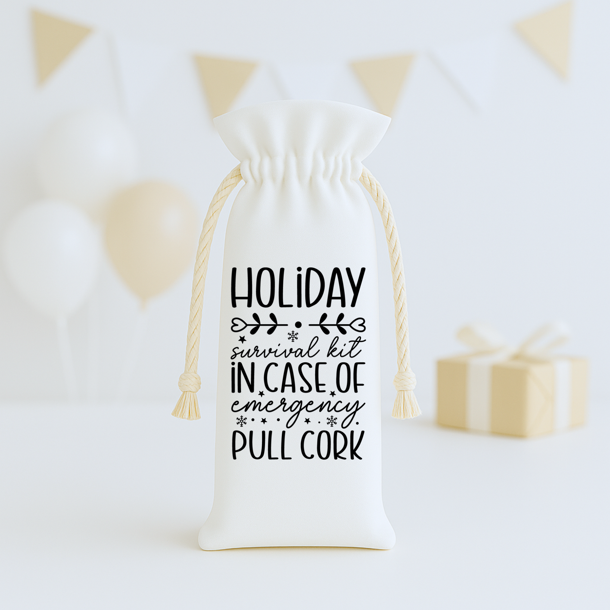 White holiday wine bag with playful survival kit design, styled with balloons and wrapped gifts.