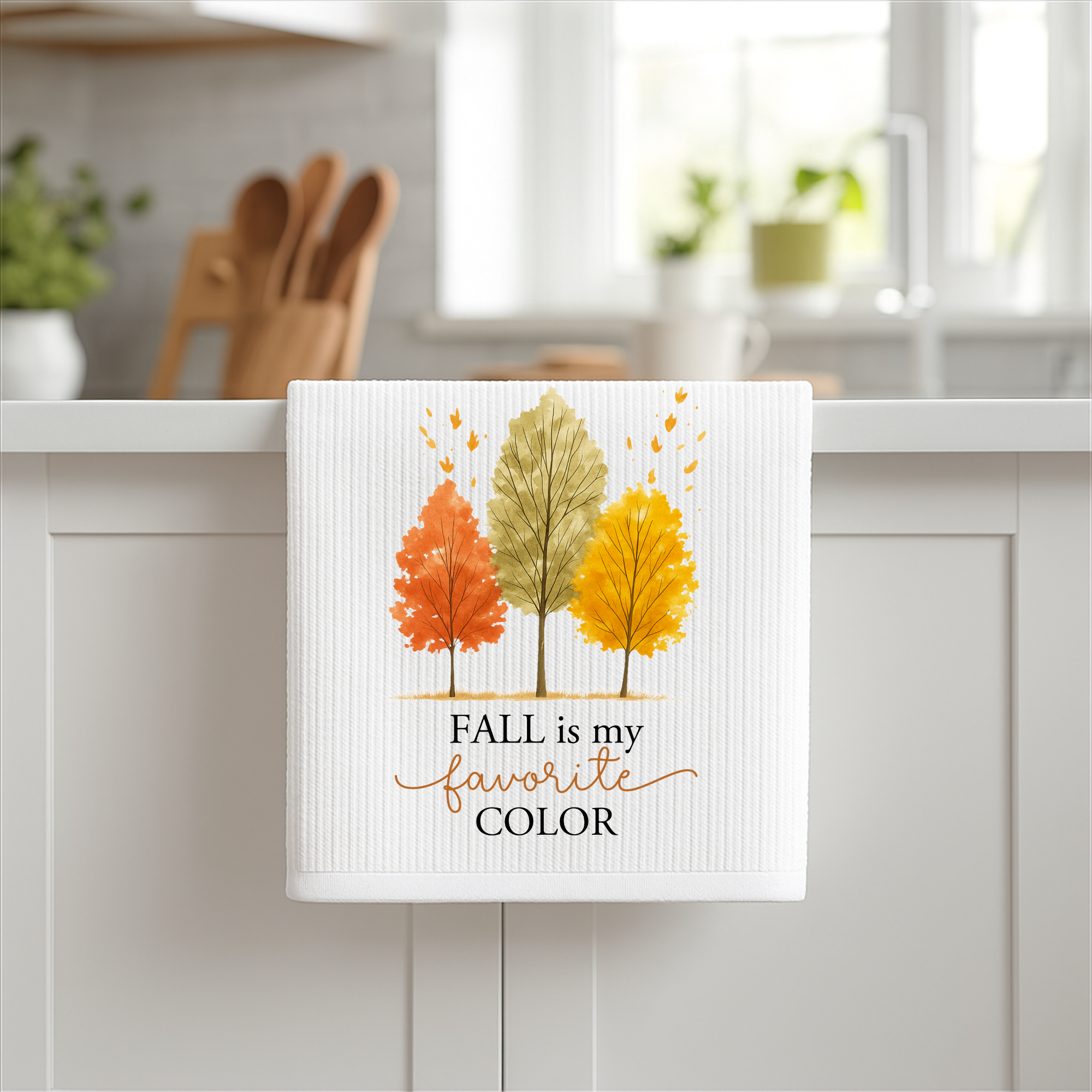 Fall kitchen towel with “Fall is My Favorite Color” quote displayed on a white cabinet, autumn home decor photography.