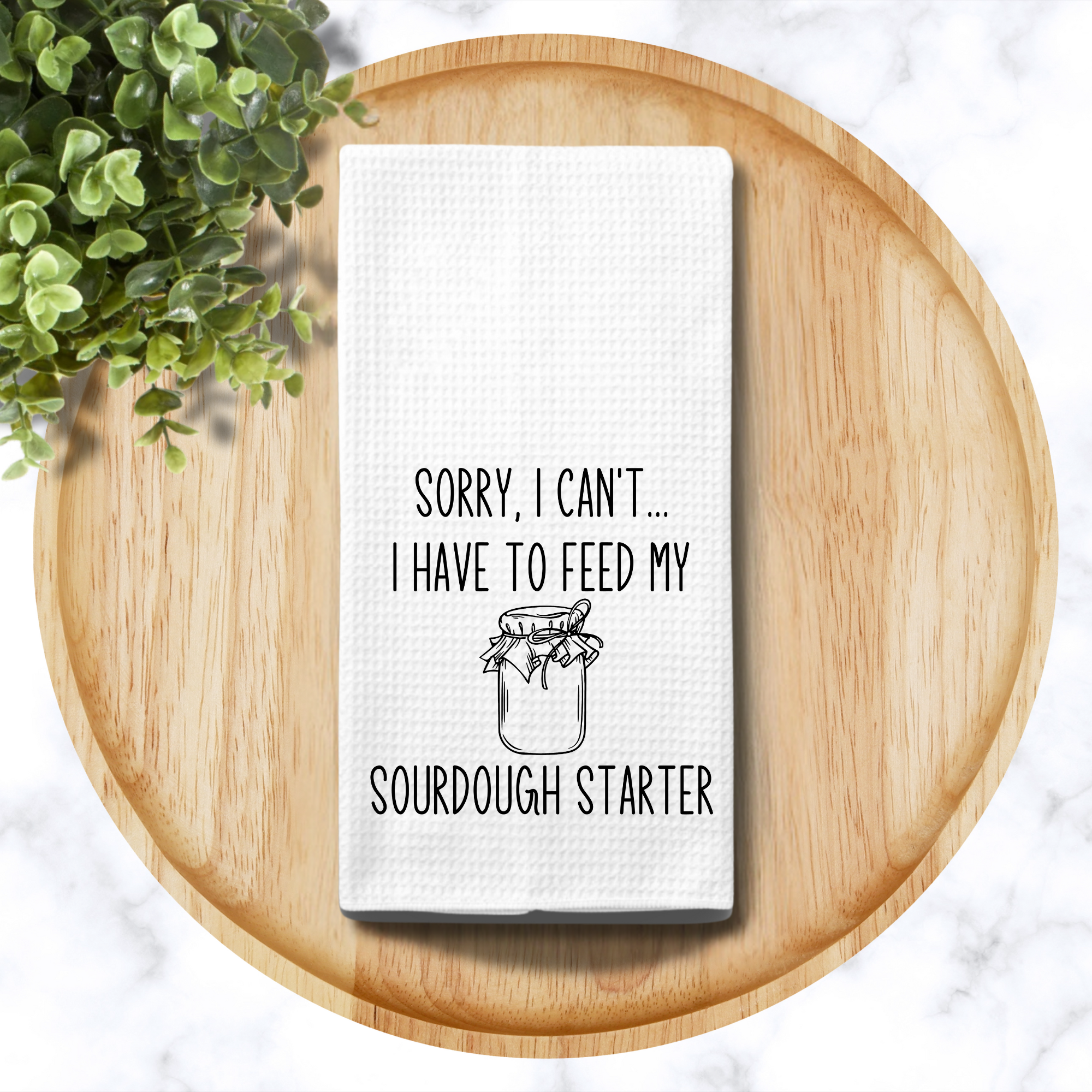 Sourdough quote towel on round wood tray with greenery – aesthetic kitchen accessory for baking fans.