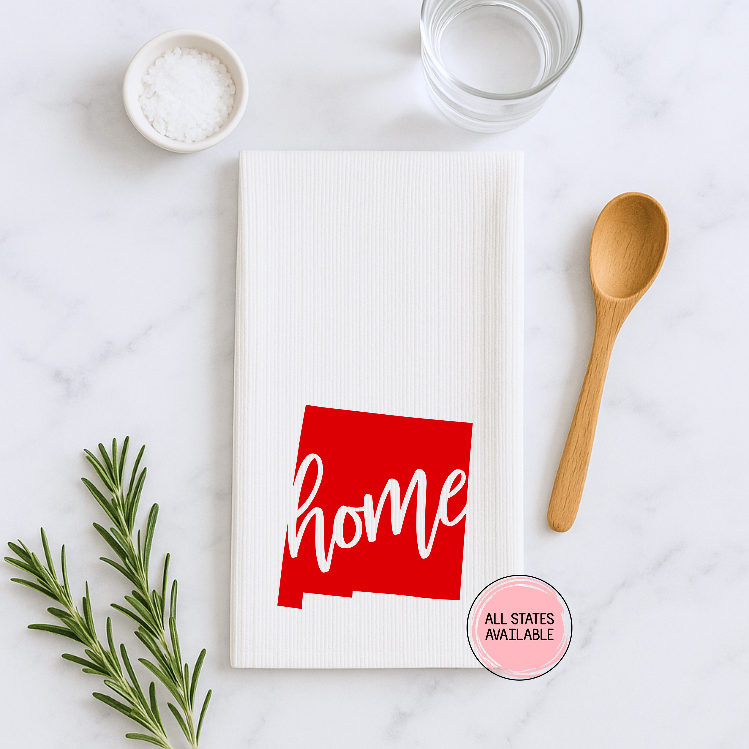 Flat lay of a New Mexico home state waffle weave kitchen towel with red state design styled with cooking utensils.