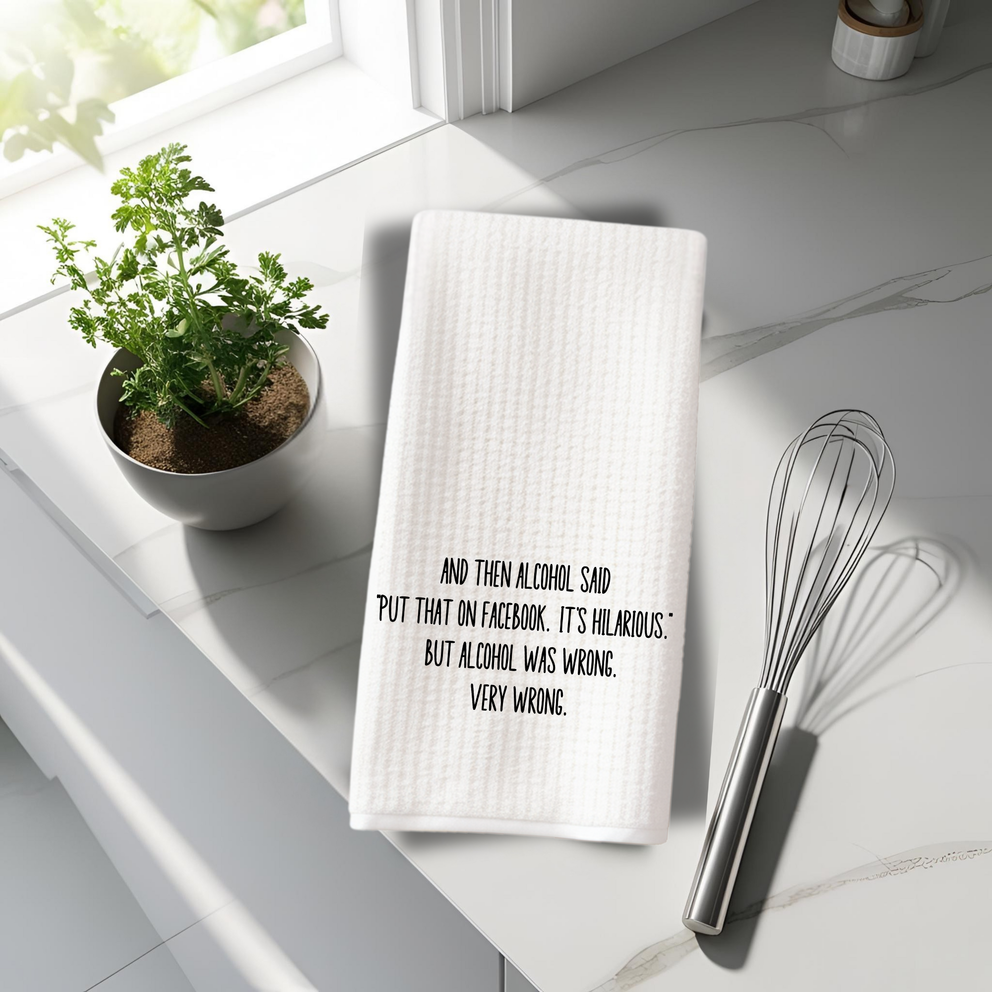 Funny kitchen decor towel with witty alcohol quote, styled on a marble countertop with whisk and potted herb.