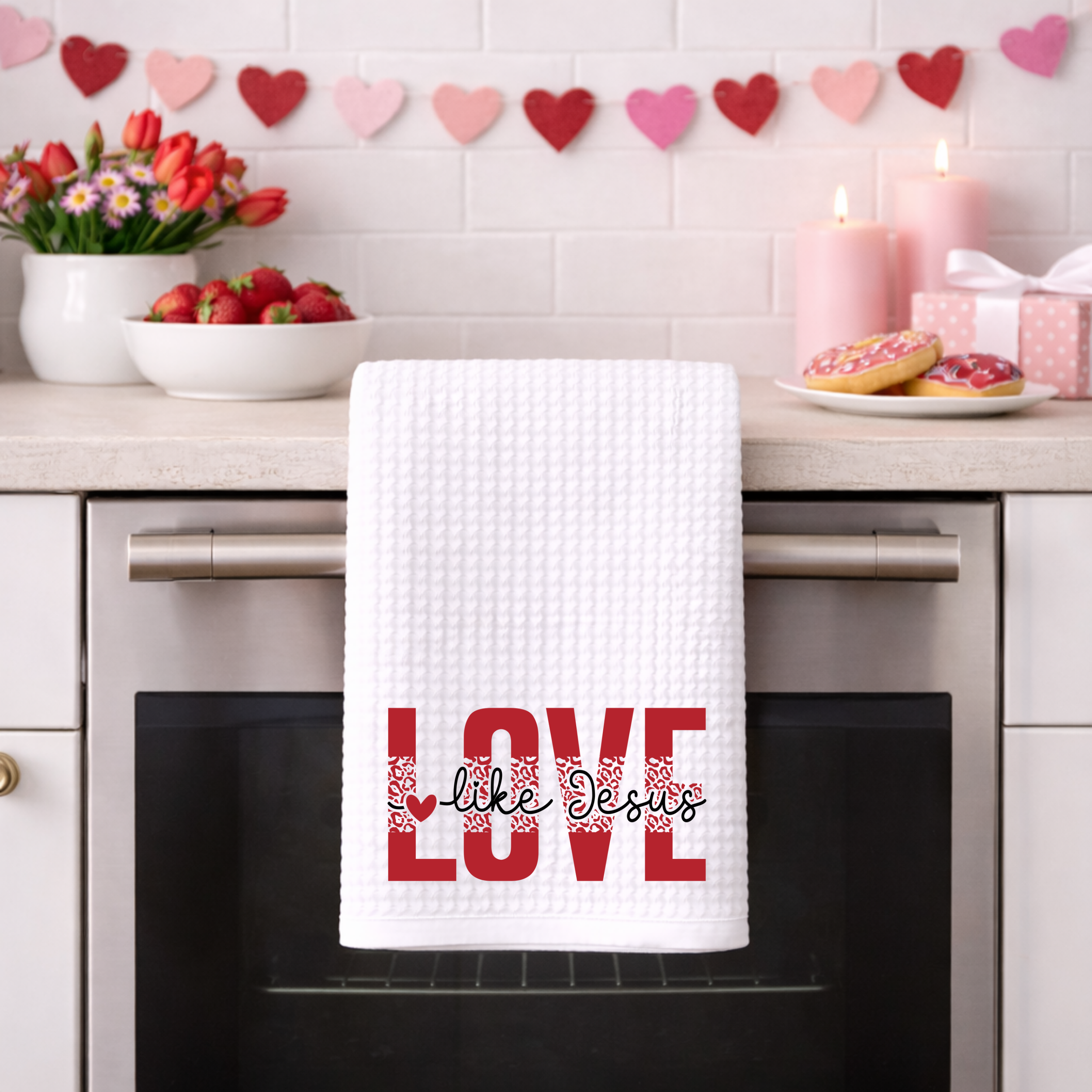 Christian “Love Like Jesus” waffle weave towel hanging on oven with Valentine decor.
