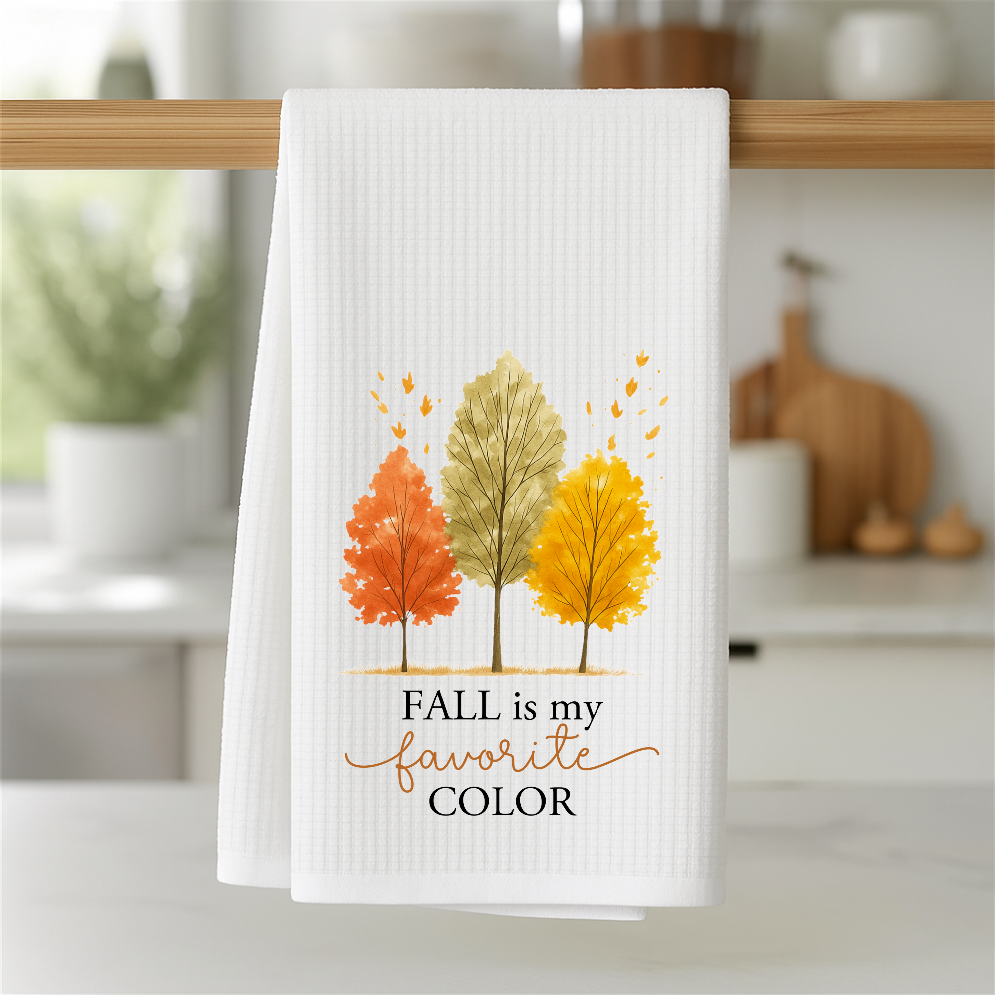 Autumn dish towel with watercolor trees hanging on a wooden kitchen bar, fall farmhouse kitchen accessory.