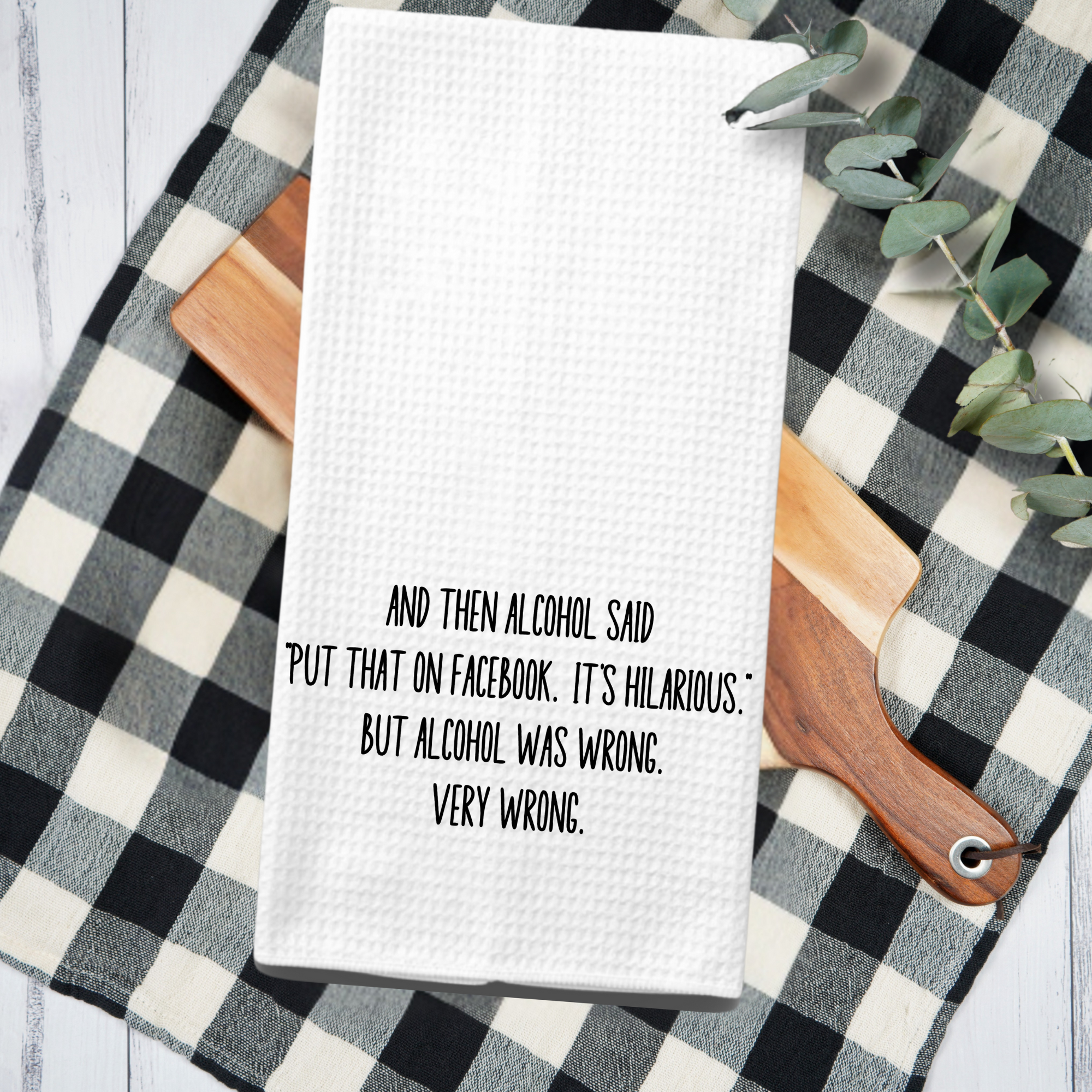 Farmhouse kitchen towel with sarcastic alcohol quote, styled on a buffalo check towel and wooden cutting board.