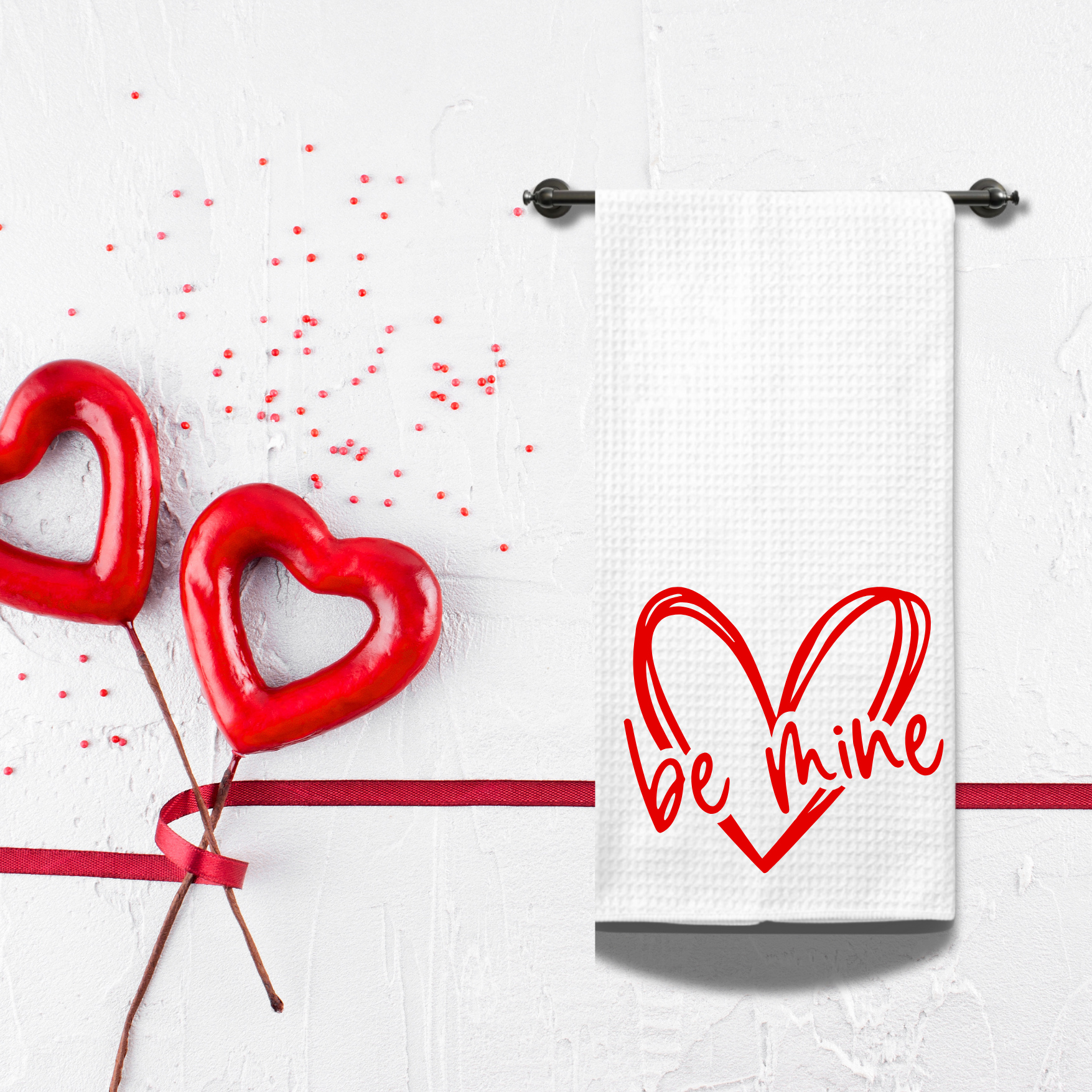 Hanging romantic tea towel with a bold red heart design, styled with festive Valentine's Day decor.