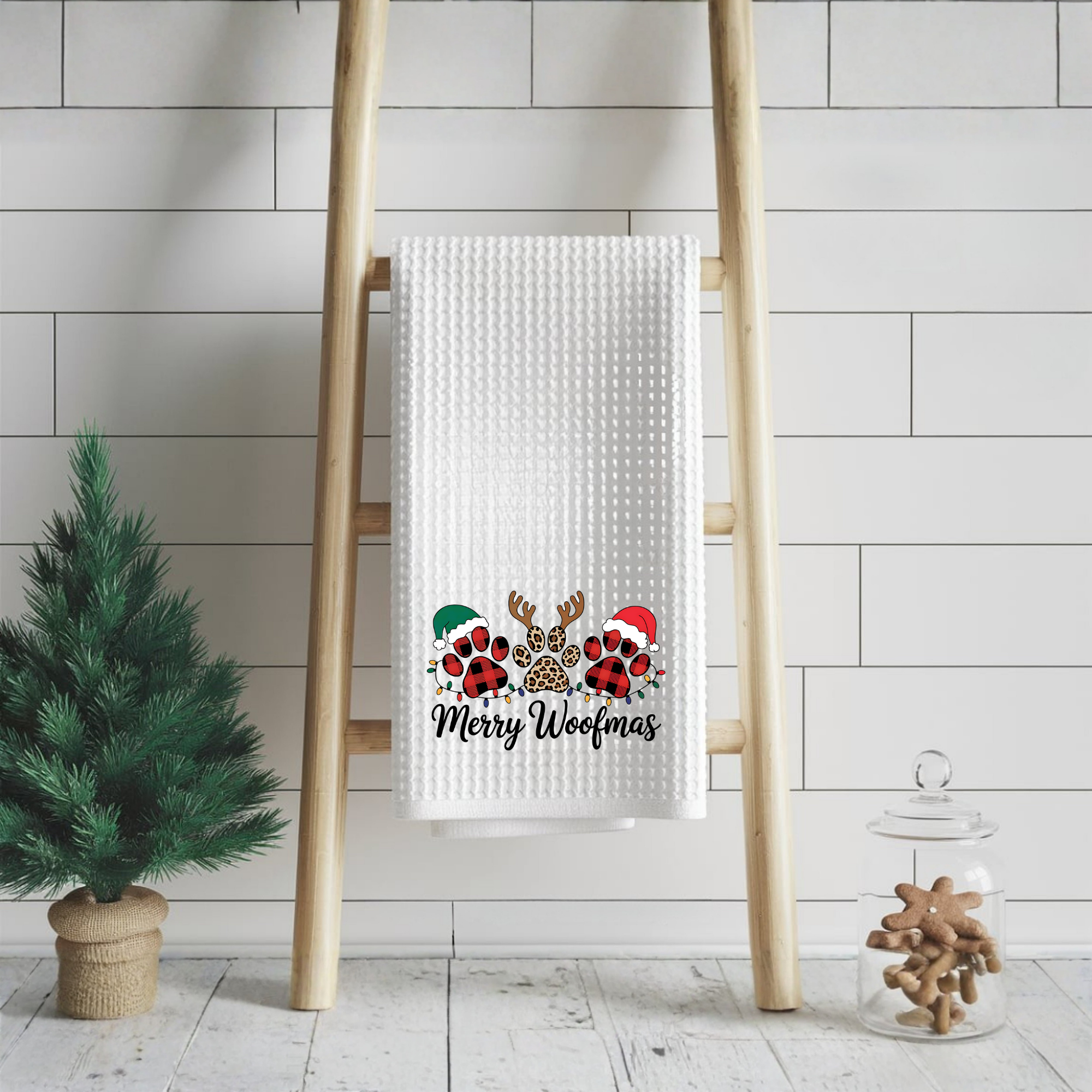 Merry Woofmas dog Christmas kitchen towel hanging on a wooden ladder with festive holiday decor.
