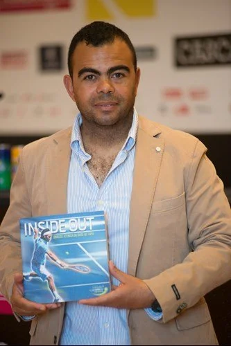 Man holding a book titled 'Inside Out' at a bookstore or event.