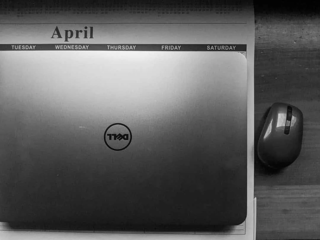 A laptop and wireless mouse on a desk.