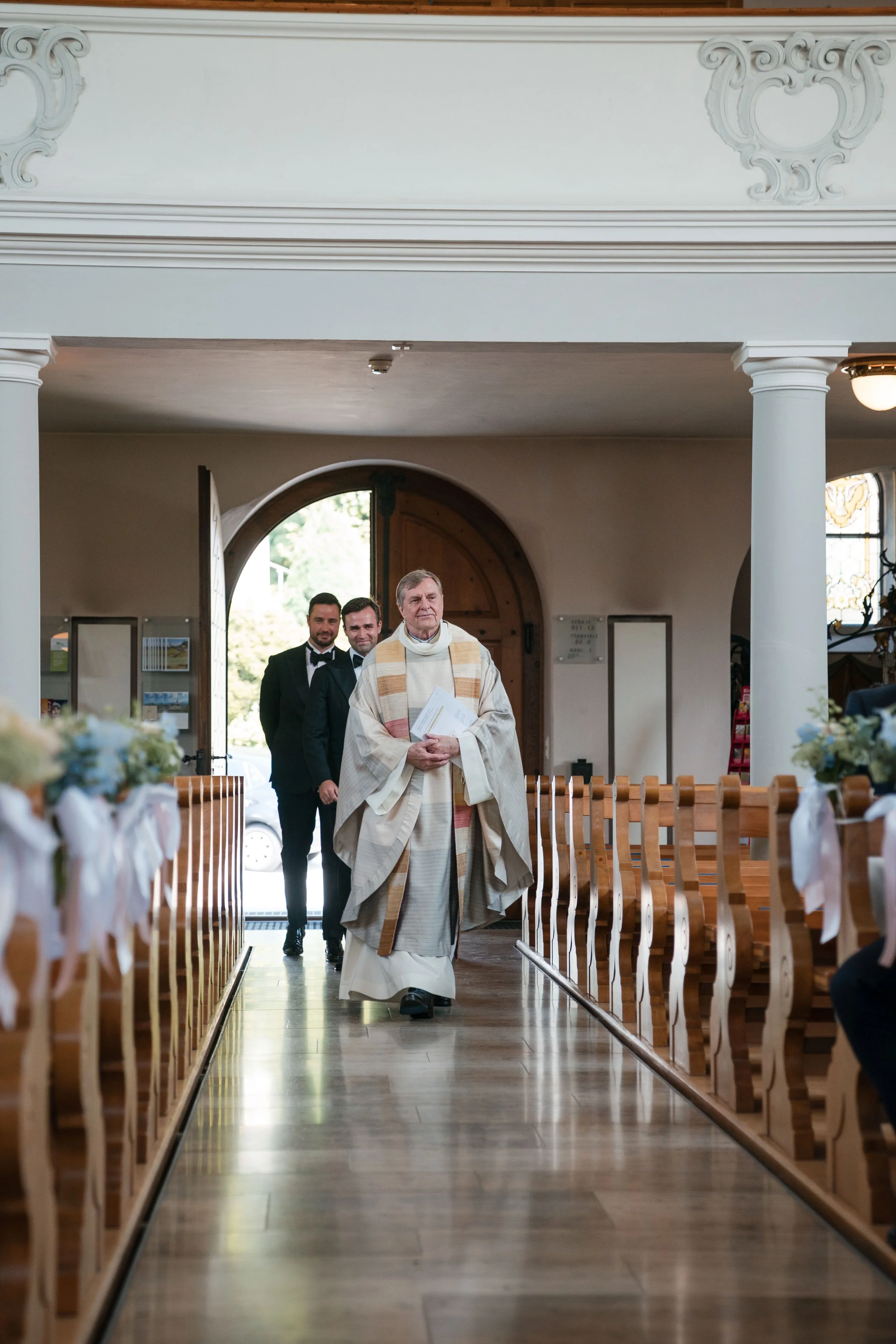 Pfarrer führt Trauung in Kirche mit Brautpaar und Gästen durch