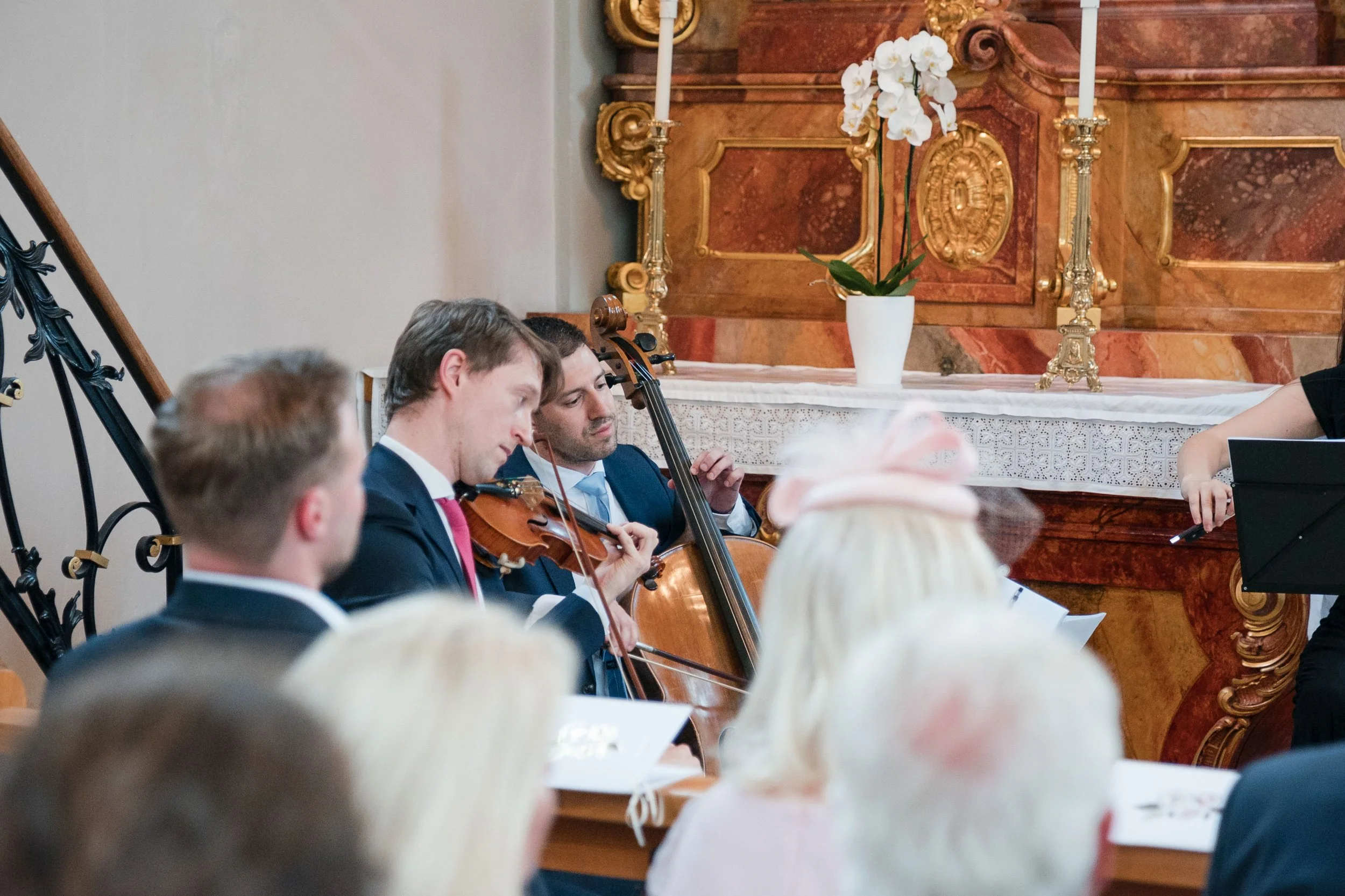 Musiker spielen Geigen bei einer klassischen Konzerthalle.