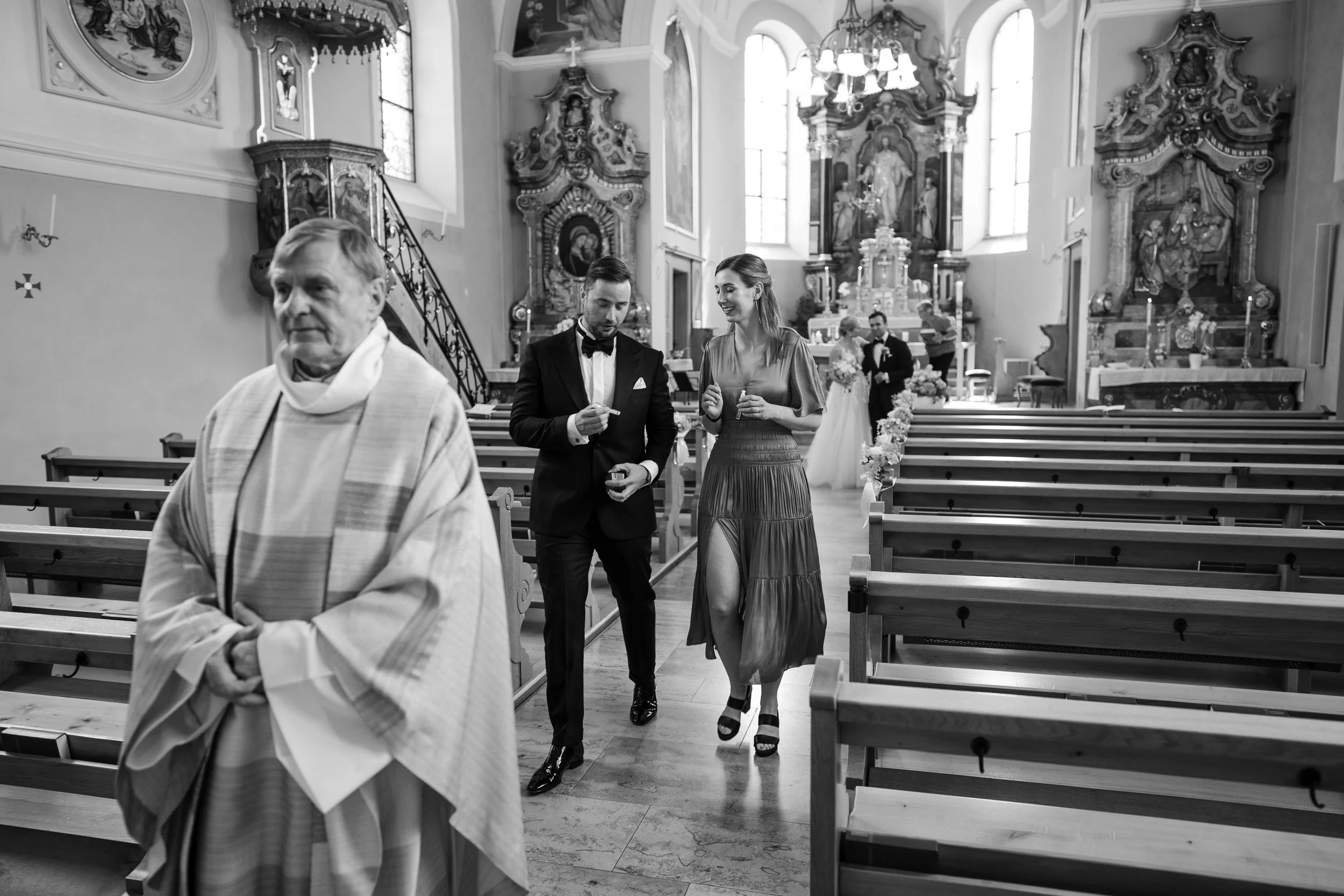 Paare und Gäste in einer Kirche während einer Hochzeitsfeier