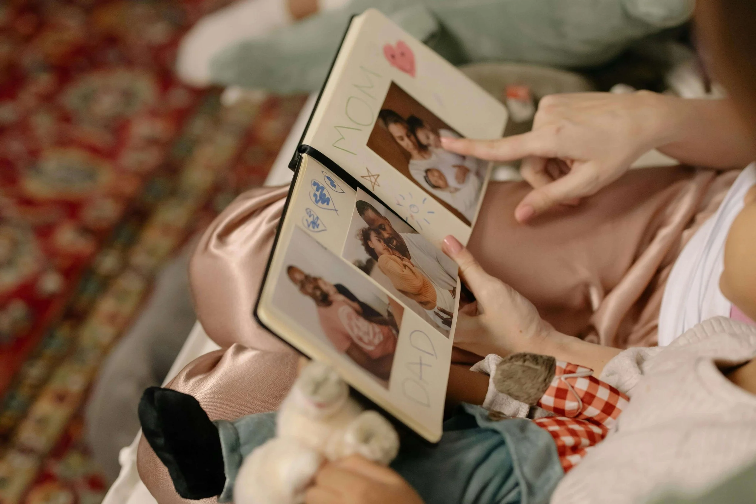 Person flipping through old photos, illustrating how past experiences are explored with a psychodynamic postpartum therapist in Washington, DC.