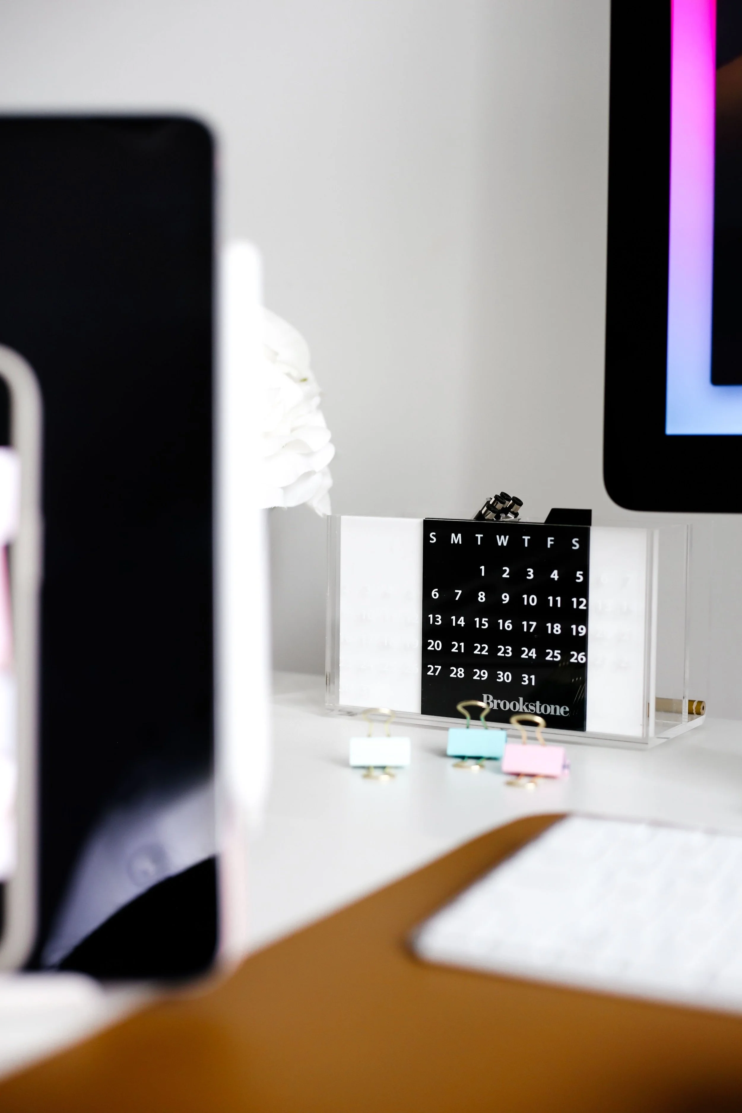 A desk calendar sits between screens on a busy desk. When a full life leaves no room, psychoanalysis Washington DC asks what fills your week. Psychoanalytic therapy in Washington, DC and psychotherapy analysis Washington help you look closer.