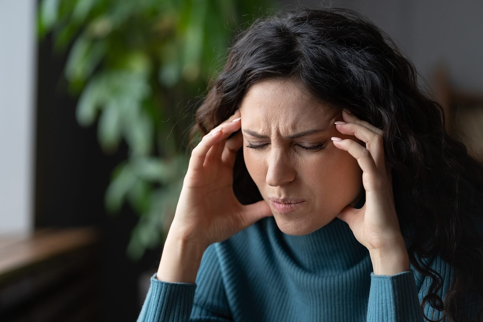 A woman presses her fingers to her temples, strained, the kind of symptom psychodynamic therapy in Washington, DC explores as a coping attempt. A psychodynamic therapist in Washington, DC using a psychodynamic approach in Washington, DC can help.