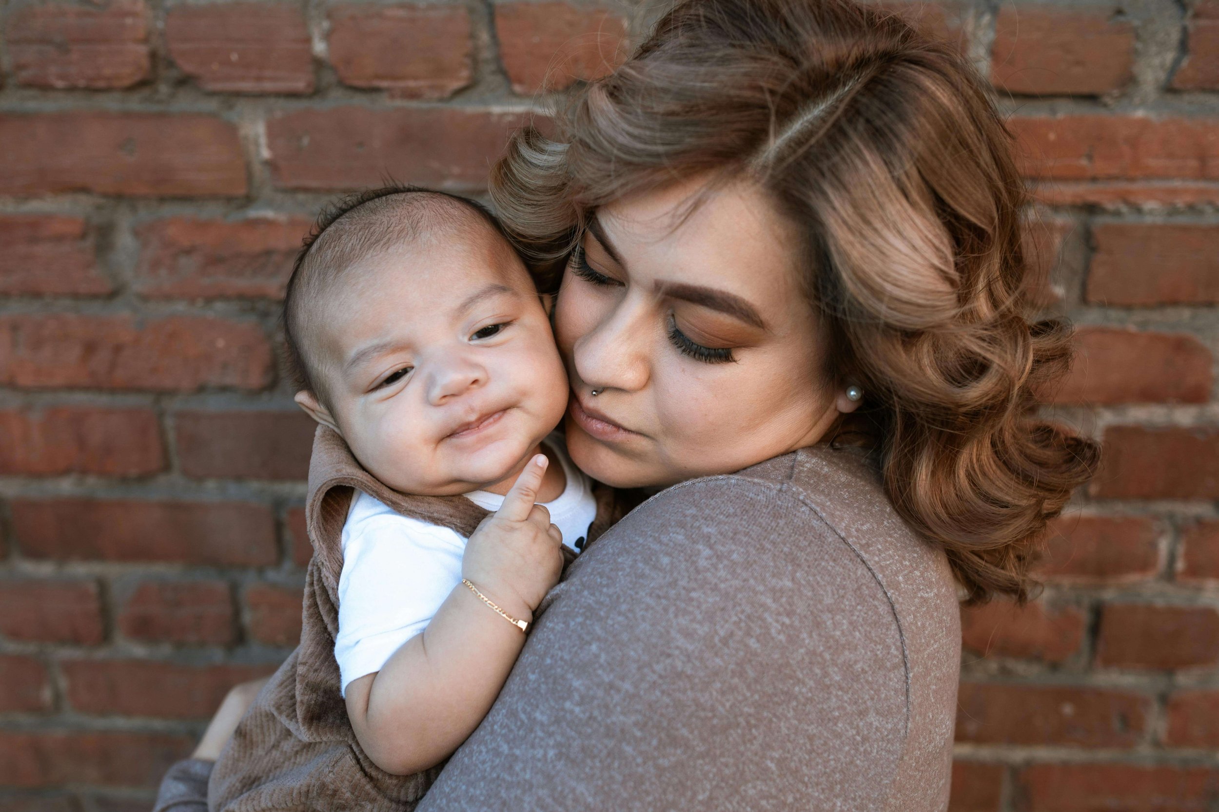 Close-up of a woman holding her baby while looking thoughtful, representing reflection and emotional processing around new mom guilt in Washington, DC.