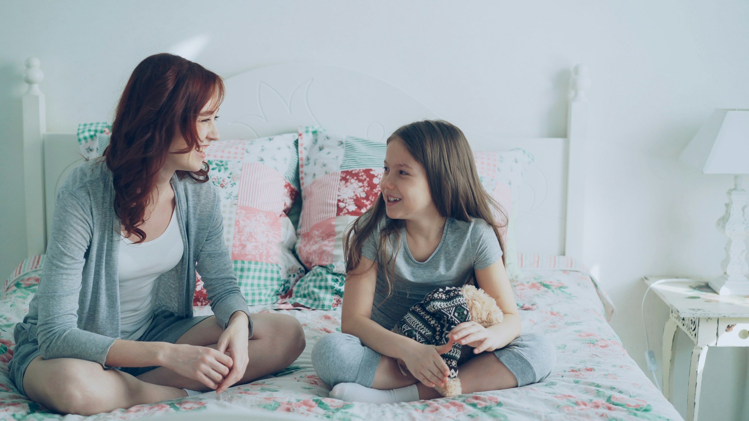 Mom and daughter sitting together engaging in healthy conversations about difficult topics around the news cycle