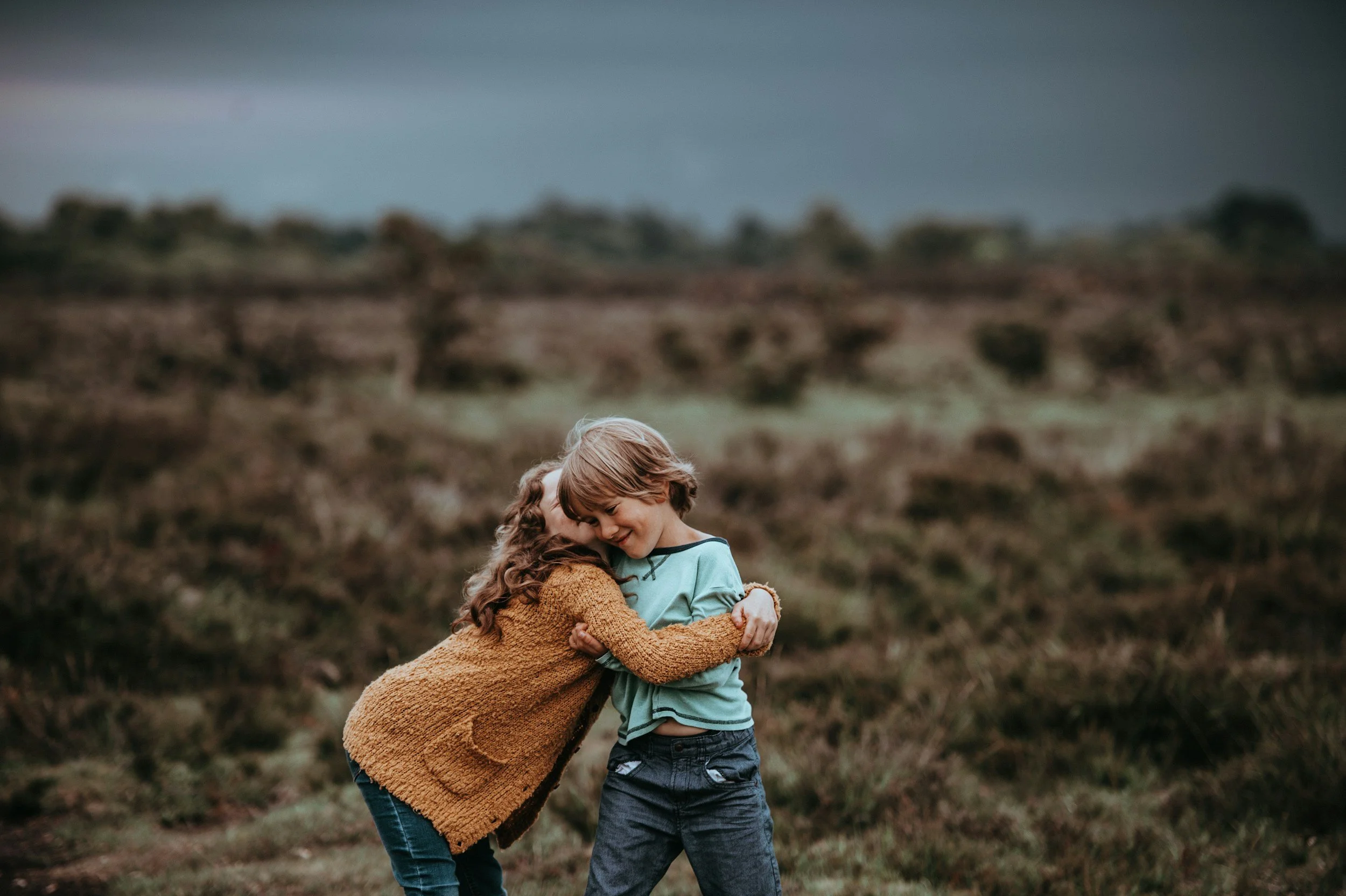 A young boy giving a girl a warm hug, illustrating the development of empathy and breaking gender stereotypes through social-emotional learning.