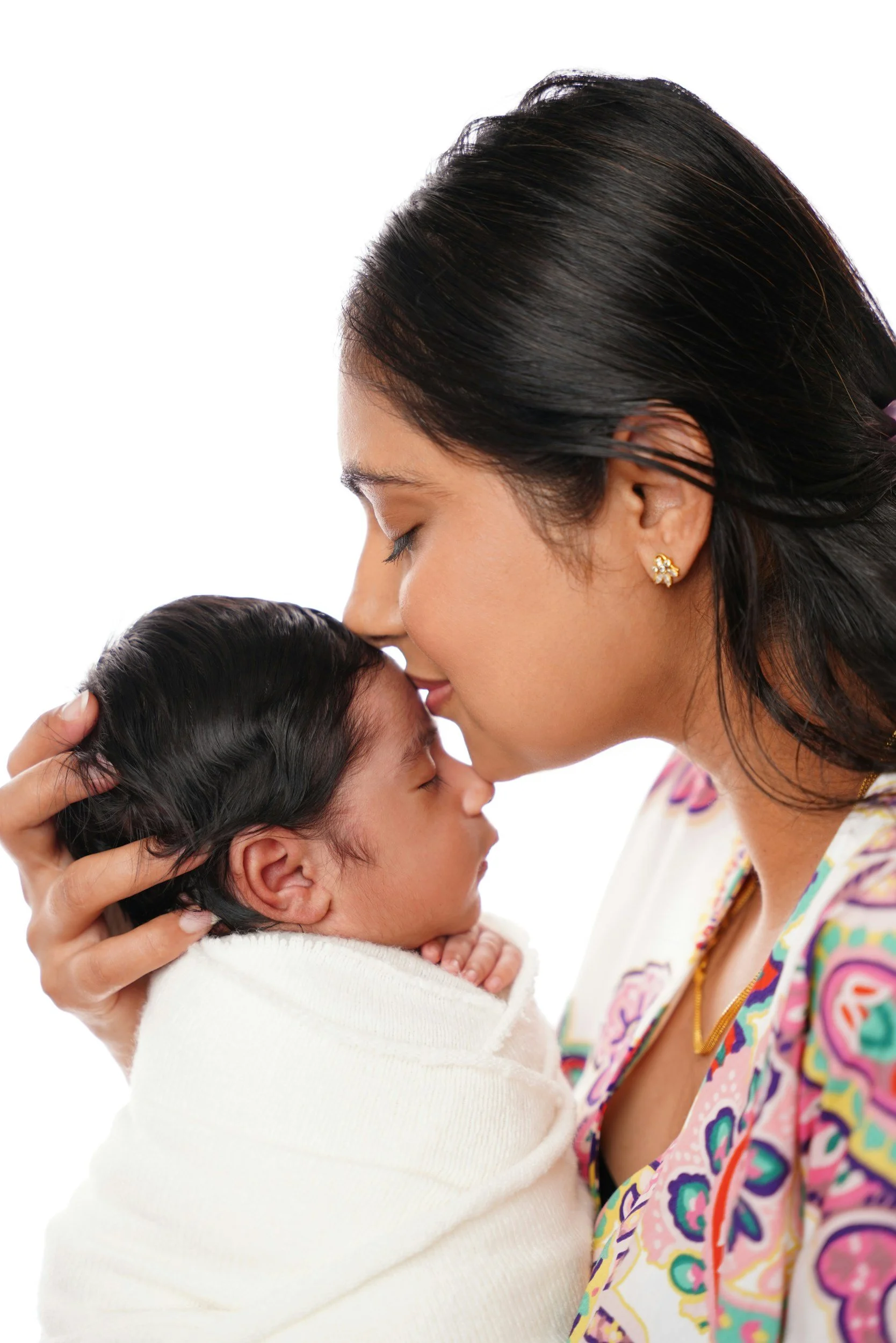 A mother gently kisses the forehead of her sleeping newborn, illustrating the foundation of 'Early Bonds Therapy' and secure attachment. Laura Todd, LPCC, specializes in supporting this connection, even after a difficult birth in Campbell, CA.