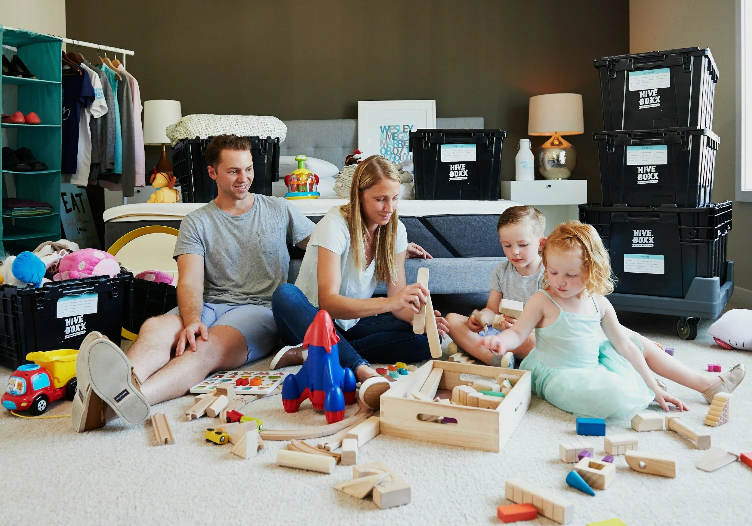 A family of four playing together on the floor, reflecting the early bonds and emotional connection supported by Laura Todd’s therapy practice.