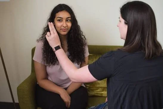 A woman in an EMDR therapy session in Campbell, CA, following bilateral eye movement processing for birth distress with a licensed perinatal therapist.