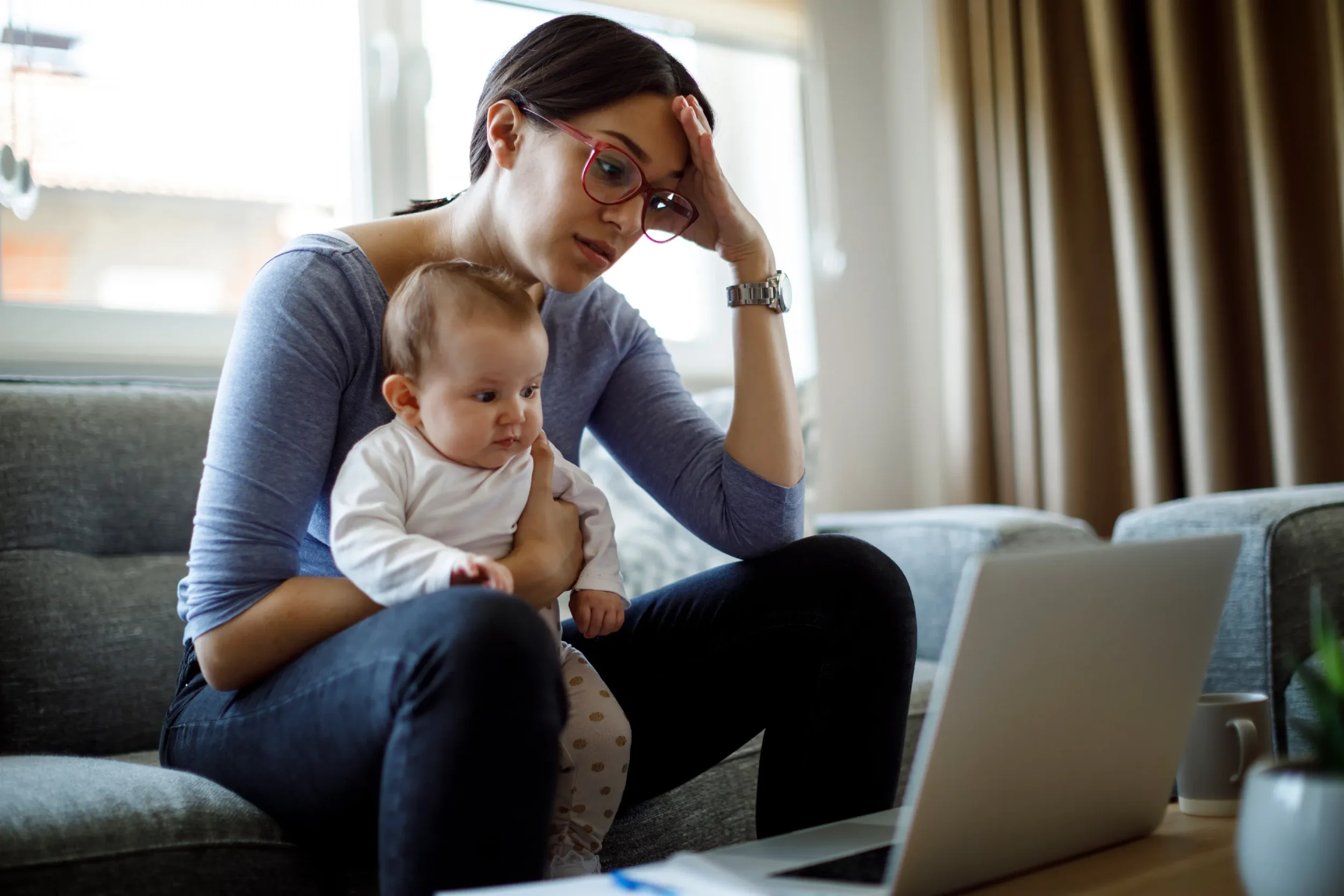 Working Mom holding her baby while struggling with Depressed Anxious about the news cycle