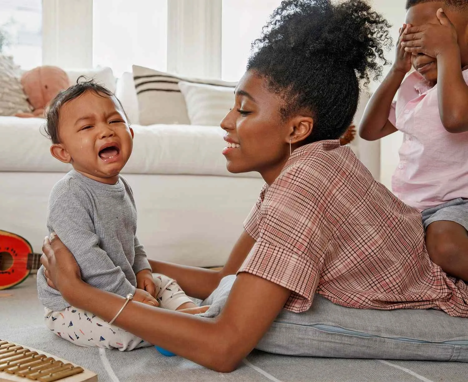 Mother soothing a crying baby, using somatic regulation to calm the shared nervous system.