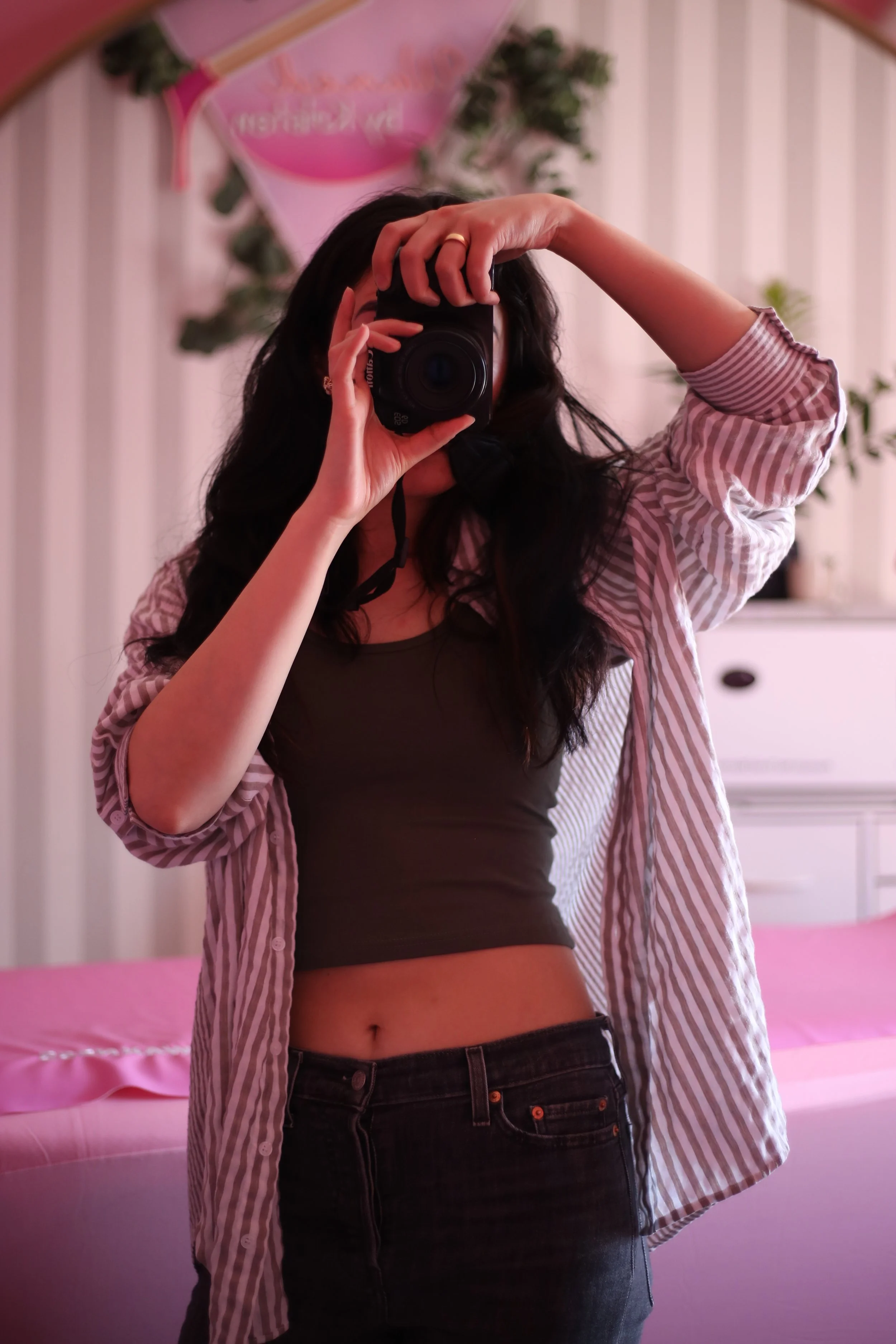 A blurry image is shown of a person sitting in front of a library while the camera recording is in focus to the right. 