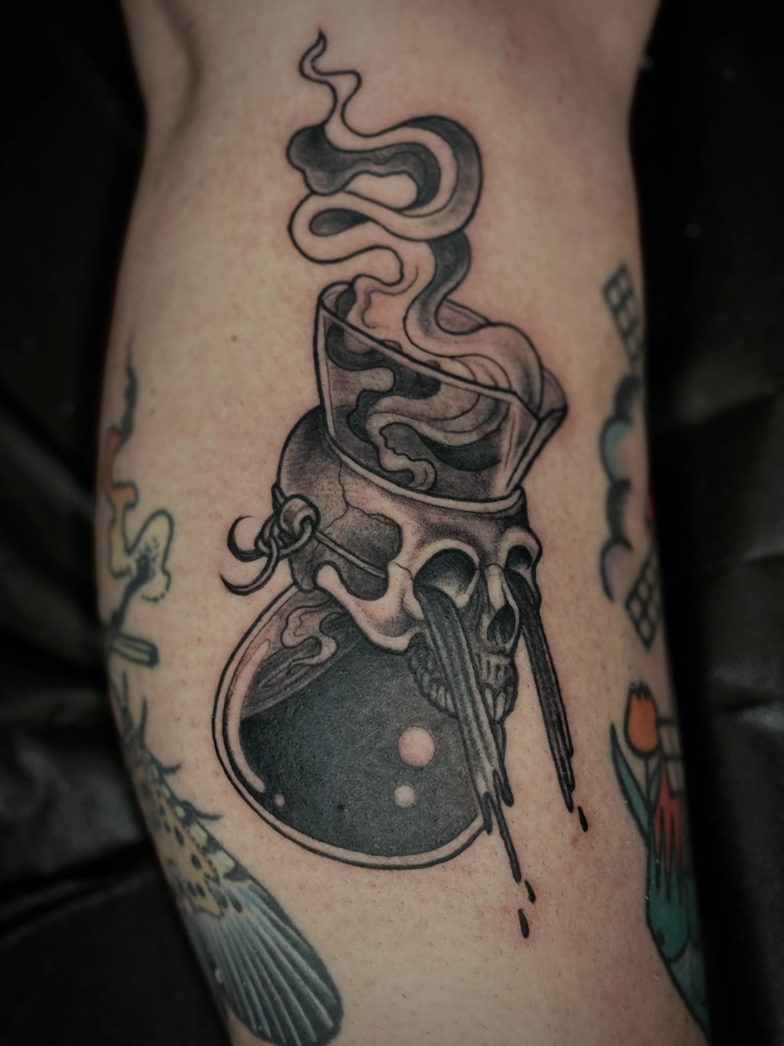 Tattoo of a Chemex with a skull, with coffee pouring out of the spout and out of the skull's eyes.