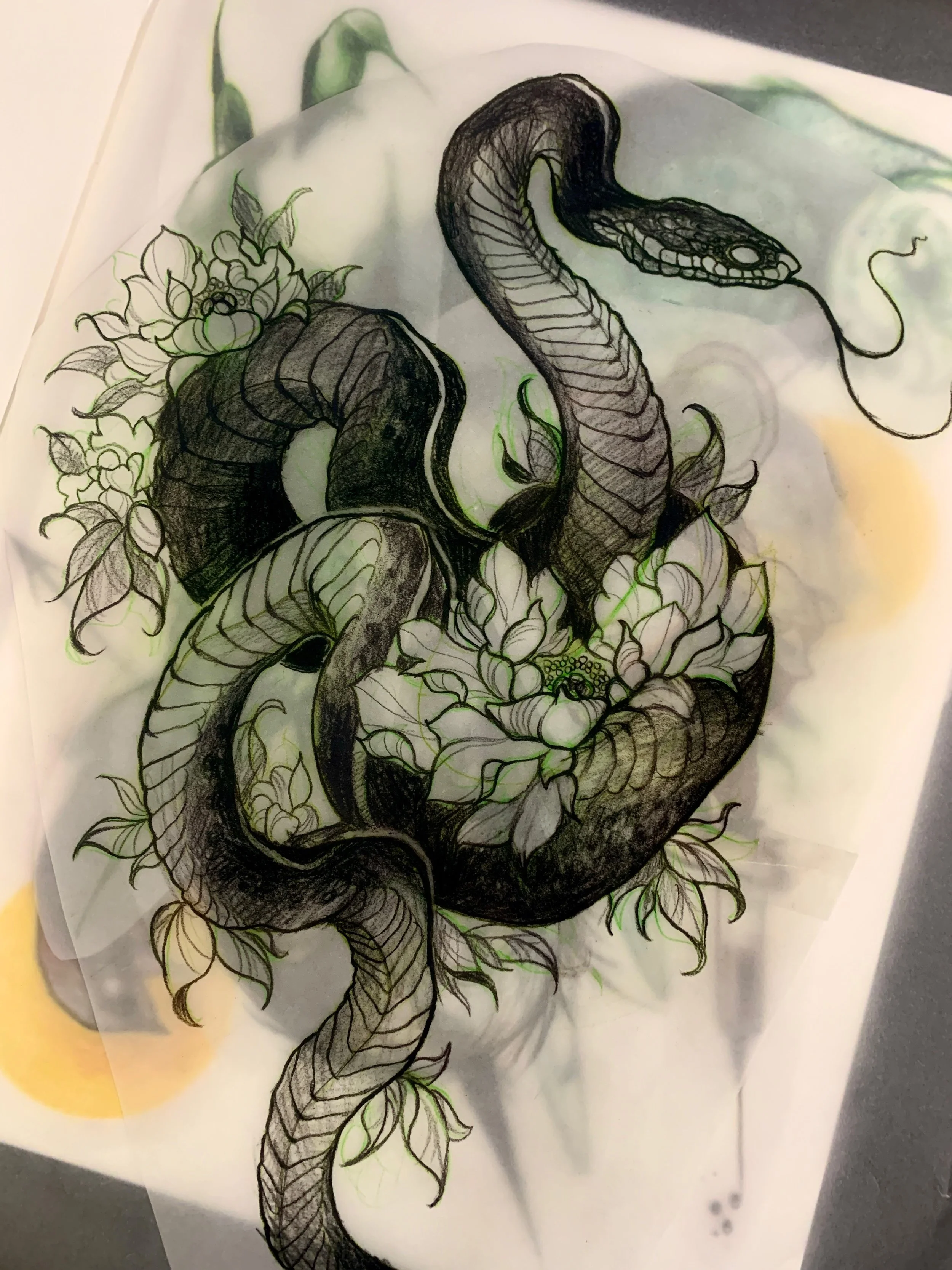 A tattoo design of a snake intertwined with flowers and leaves.