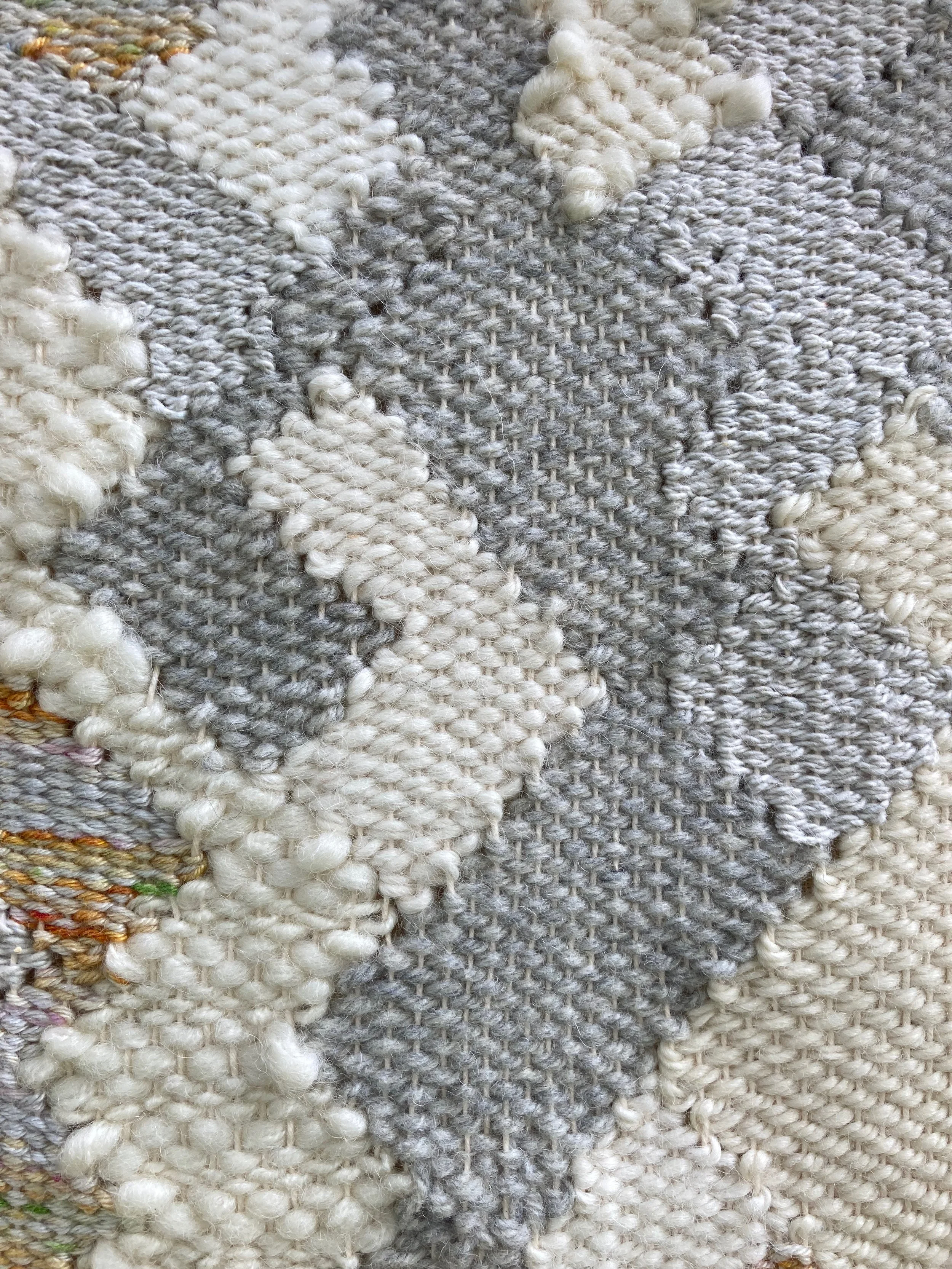 Close-up of a textured, woven fabric with a gray and white zigzag pattern.