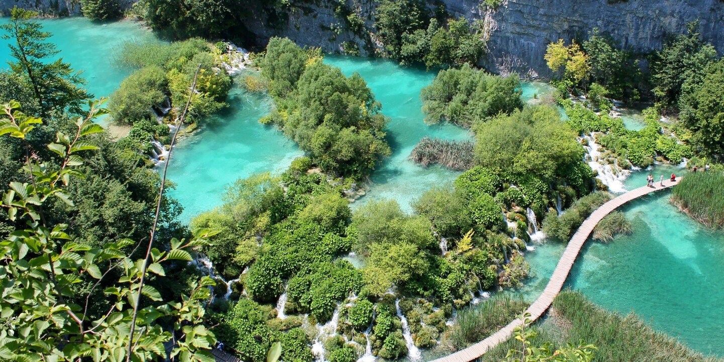 Plitvice National Park aerial view of water, tall grasses, and a pedestrian bridge
