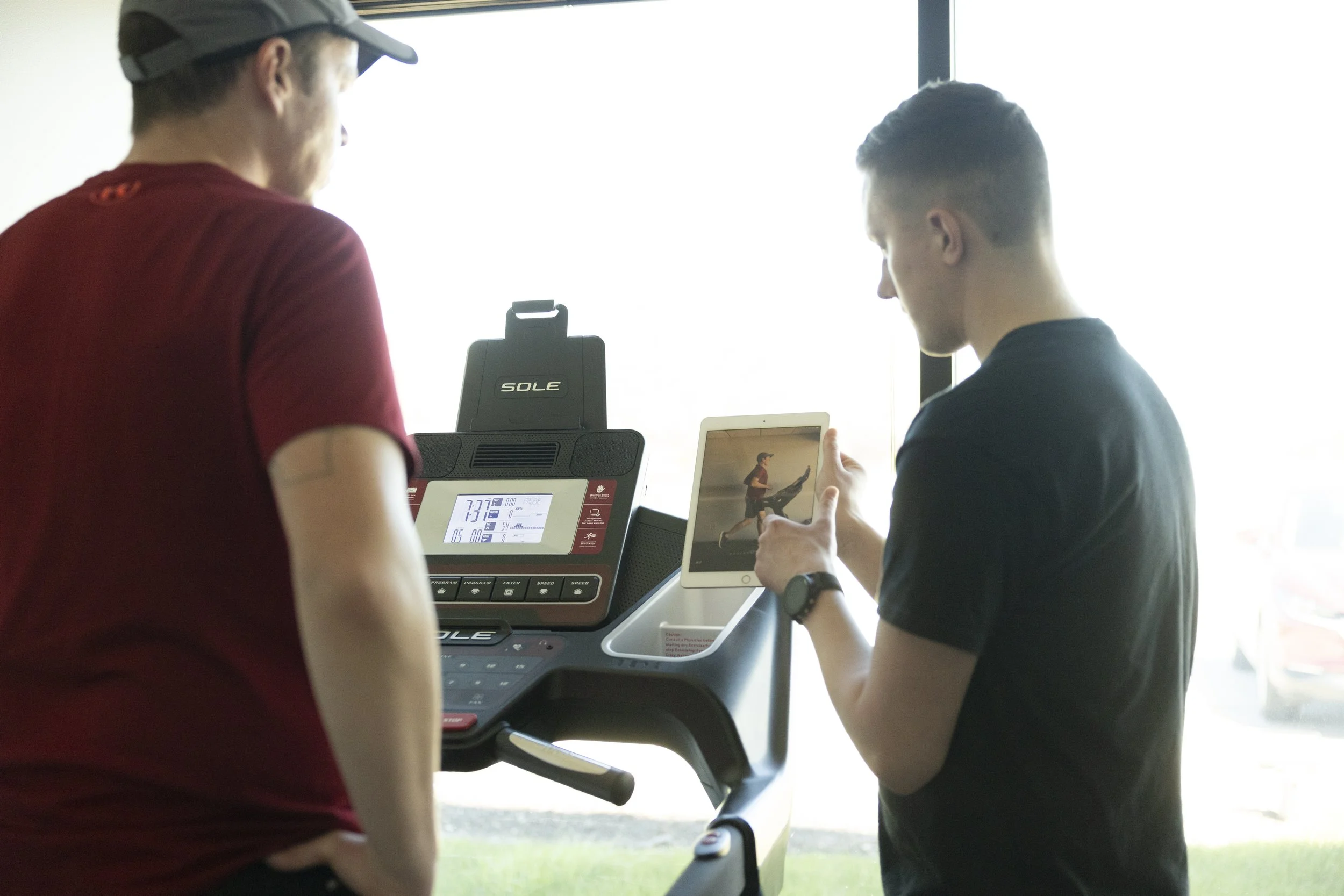 A physical therapist using a tablet to explain findings of a detailed video gait analysis